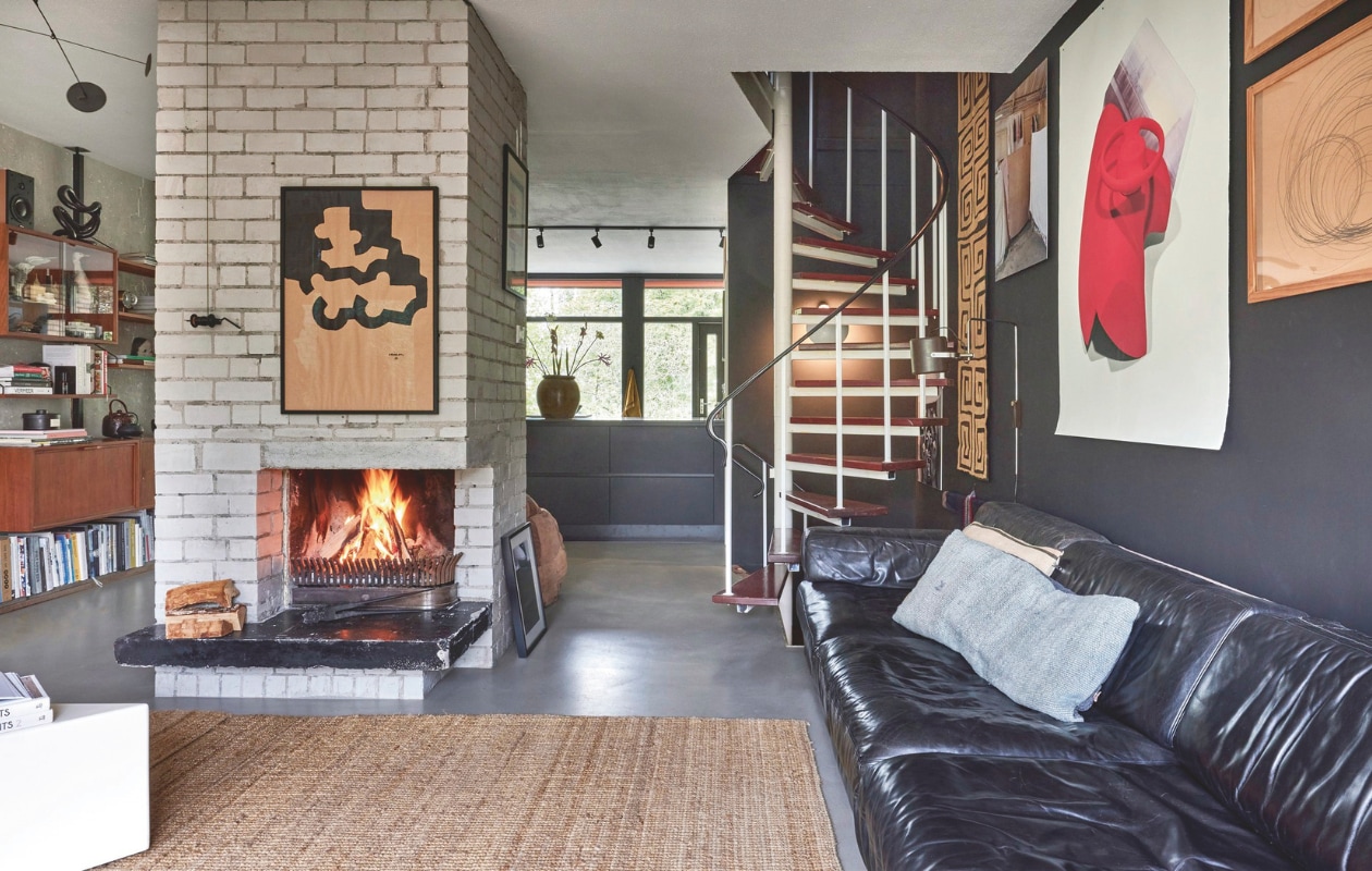 Werk boven de open haard Eduardo Chillida. Lamp vintage. Origineel Afrikaans wandkleed, foto Henk Wildschut, rode print Scheltens &amp; Abbenes. Bank vintage De Sede. Kussen Yazgibi. vtwonen 11-2024 | styling Fietje Bruijn | fotografie Alexander van Berge