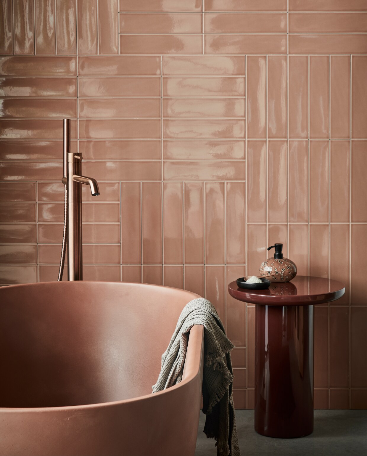 vtwonen collectie vloeren en tegels, Vloertegels Raw Grey, 80x80 cm per m² € 79,95, wandtegels achter bad Shapes Toffee glans, 7,5x30 cm per m² € 58,99, detremmerie.be (bad), polspotten.com (bijzettafel Mob), vtwonen.nl (badmat van Ferm Living, marmeren schaal en zeepdispenser Ugo van Aquanova), Uit de vtwonen badkamercollectie: vrijstaande badkraan Roma van Plieger. Overig privébezit. vtwonen 02-2023 |  styling Sanne Ketelaar | fotografie Peggy Janssen