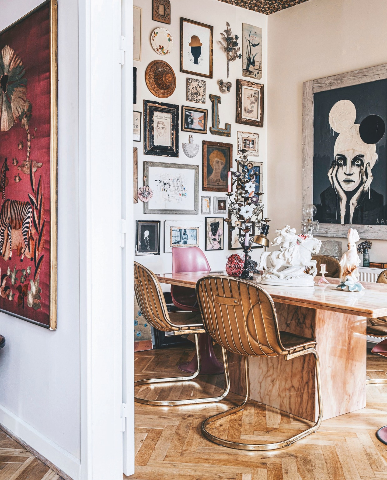 Parketvloer antiek, schilderij meegenomen uit Frankrijk, eetkamerstoelen van een Italiaanse designer, roze stoel en roze marmeren eettafel vintage. Zwart-wit- schilderij portret van Maria geschilderd door een vriend. vtwonen 11-2024 | styling Lina Vertus | fotografie Isabell Wedin