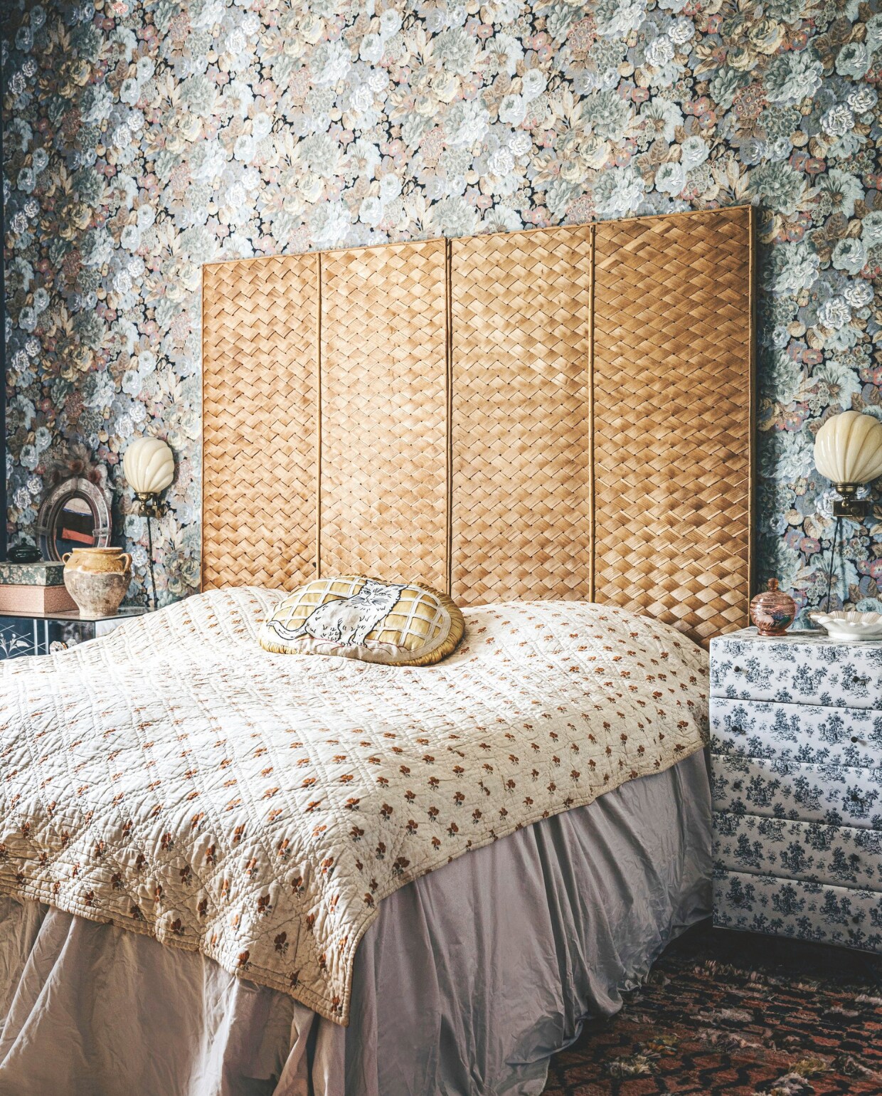 Hoofdboord van het bed en kussen op bed vintage. Vintage behang en vintage muurlampen uit Frankrijk. vtwonen 11-2024 | styling Lina Vertus | fotografie Isabell Wedin