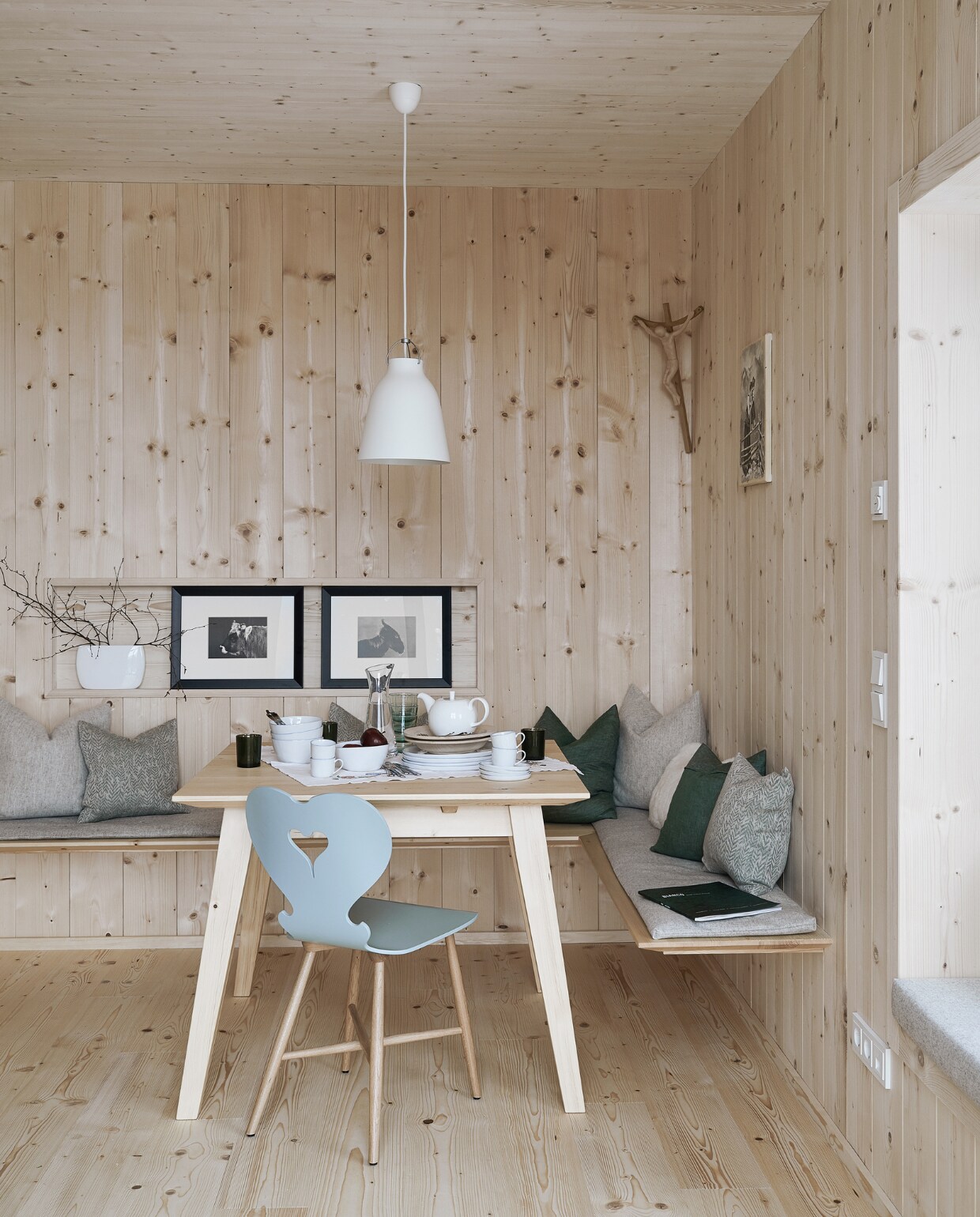 Vurenhouten wandbekleding en vloer. Tafel op maat gemaakt door een lokale timmerman, stoel Trix van Schmidinger Möbelbau. Linnen kussens van Leitner Leinen, wollen kussens van Loden Steiner. Servies Piana van Lambert, hanglamp Caravaggio van Fritz Hansen, ingelijste prints uit een kalender. Herkomst overige items onbekend. productie Features &amp; More | styling Wilma Custers | fotografie Krista Keltanen | tekst Chantal Hintze | tekstbewerking Marije Toxopeus