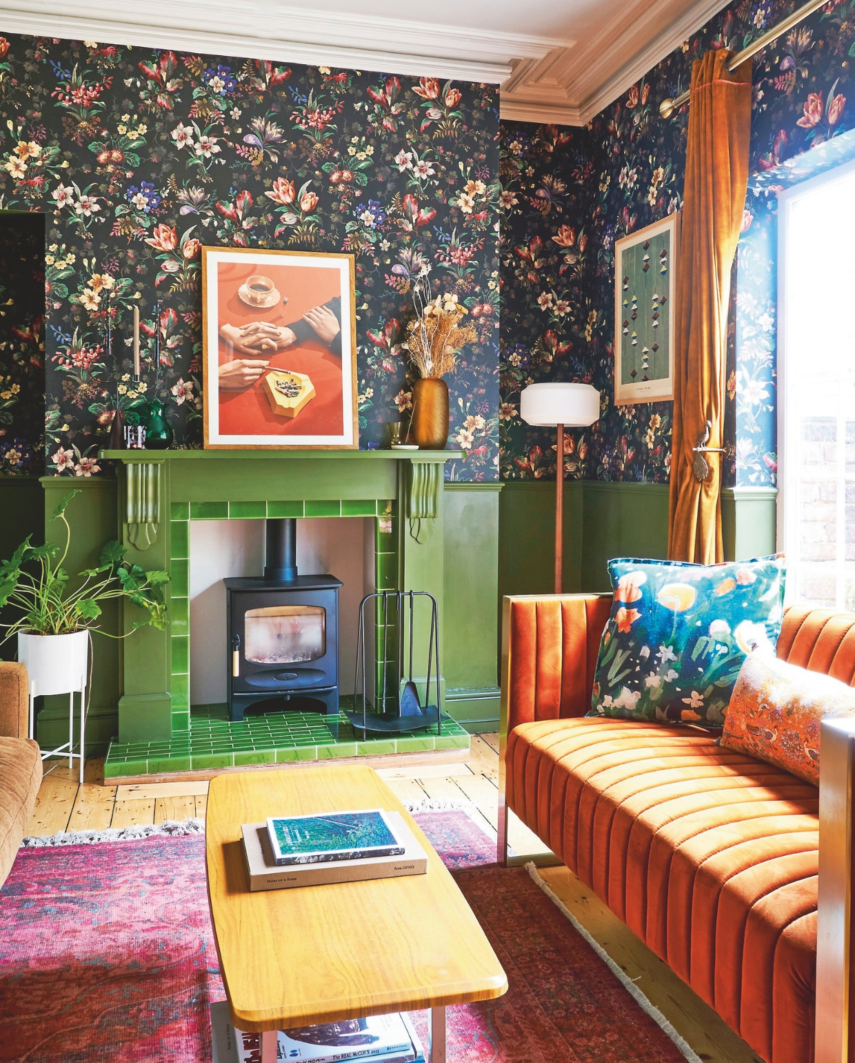 Oranje bank Rockett St. George. Vloerkleed French Connection Home. Vaas en bloempot Hübsch. Gordijnen Made. Gordijnhaak Anthropologie. Tafel vintage. Haardaccessoires Black Fire Accessories. Kussens Izzy Izzy Studio. Verf Olive van Little Greene. Kunst op schouw Henrik Bülow, behang Tulipa van House of Hackney. vtwonen 11-2024 | productie Living Inside | fotografie claire bingham