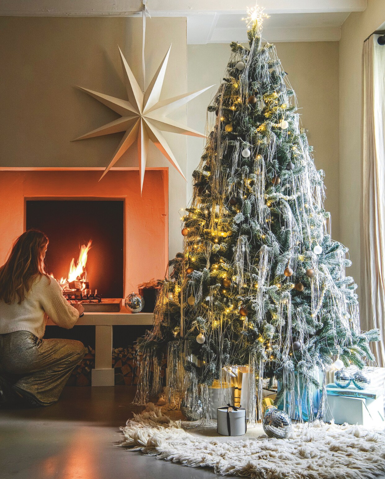 Kerstboom Nordmann € 55,- (buitengoeddeboomgaard.nl). Kartonnen ster XXL van vtwonen, 110x110 cm (bxh) € 29,92, zilveren en witte lametta, per pak € 4,49, parelslinger van vtwonen, 100 cm (l) € 49,95 (vtwonen.nl/shop). Vloerkleed Norte, wol en katoen, 150x200 cm € 585,- (fermliving.nl). Discoballen van House of Seasons, 10 cm (Ø), set van 2 € 5,50, en 25 cm (Ø) € 24,95 (vtwonen.nl/shop). Piek met ledlicht Glow van House Doctor € 44,95 (strong-desire.nl). Matte glazen kerstballen Juhla in antraciet, bruin en helder, set van 6 € 24,95 (blomus.com). Overig privébezit. vtwonen 12-2024 | styling Marit Saladini | fotografie Louis Lemaire