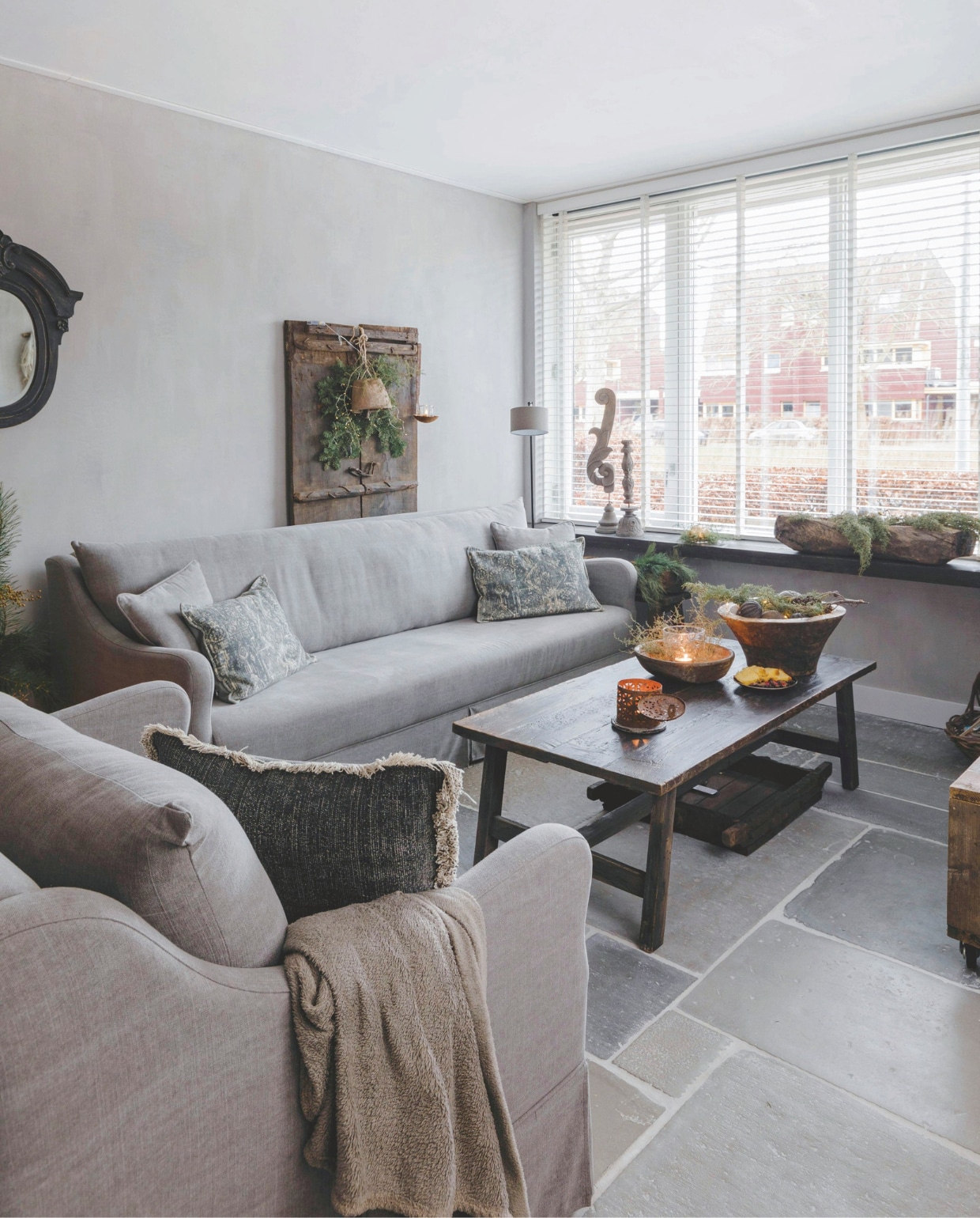 Bank en fauteuil van Rust &amp; tiek. De houten deur tegen de muur is van De Korenbloem Landelijk &amp; Sober Wonen, de bel en het windlicht van Met Landelijk Label. vtwonen landelijk 07-2024 | Styling Rust &amp; tiek | Fotografie Corine Hoge Bavel-Jansen