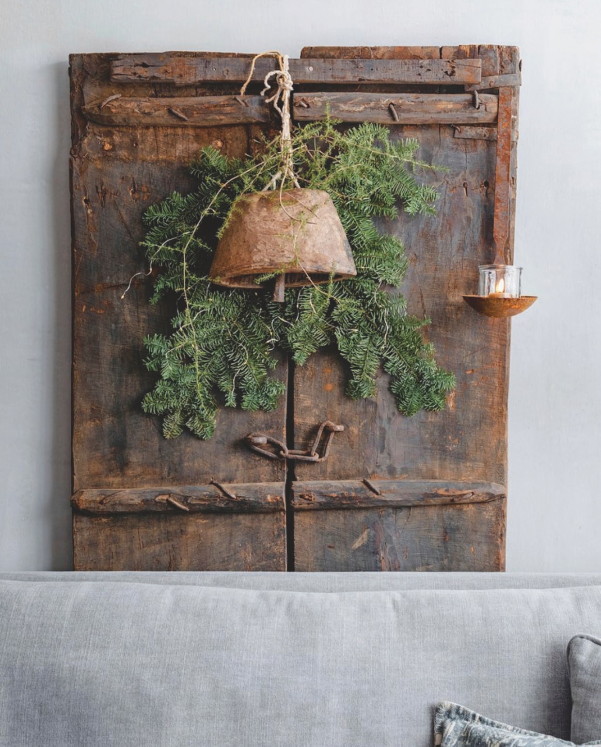 De houten deur tegen de muur is van De Korenbloem Landelijk &amp; Sober Wonen, de bel en het windlicht van Met Landelijk Label. vtwonen landelijk 07-2024 | Styling Rust &amp; tiek | Fotografie Corine Hoge Bavel-Jansen