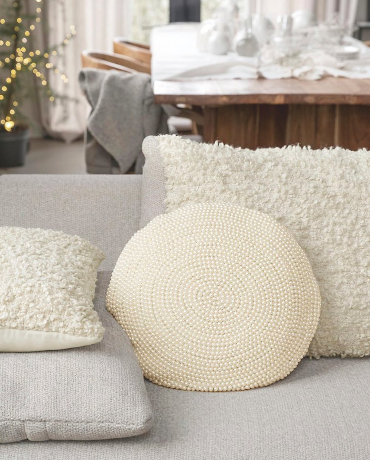 Bouclé kussen, 30x50 cm € 39,95 en 50x70 cm € 59,95. Kussen met parelkralen, 40 cm (Ø) € 59,95. vtwonen 12-2024 | styling Kim van Rossenberg | fotografie Stan Koolen