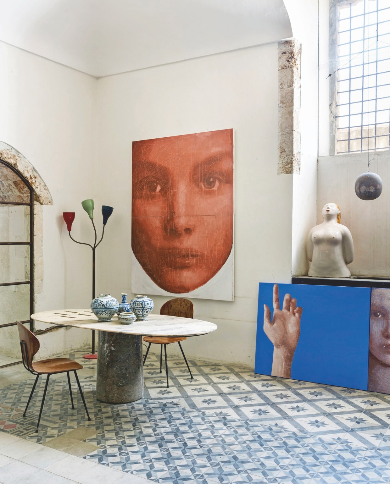 Marmeren tafel van Angelo Mangiarotti, stoelen van Carlo Ratti. Op tafel antieke vazen uit de 18e eeuw. In de hoek een jaren 50-lamp van Oluce. Keramisch sculptuur Bagnante van Ugo la Pietra, op de grond het schilderij Frammento van Sergio. Het schilderij Red Face is van ook van zijn hand. stijlvol wonen 07-2024 | fotografie en tekst Filippo Bamberghi/Living Inside
