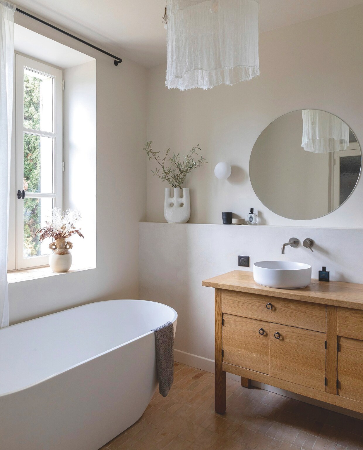 Waterafstotend laminaat Eligna van Quick-Step. Wastafelkast laten maken door een timmerman. Bad Sanycces, wastafel Leroy Merlin, spiegel op maat, opaline wandlamp Astro Lightning, vaas vensterbank Maison Bonjour, vaas rechts Le Coin Sauvage, muurverf Joa’s White van Farrow &amp; Ball. vtwonen 12-2024 | styling Marie-Maud Levron | fotografie Cecile Perrinet-Lhermitt