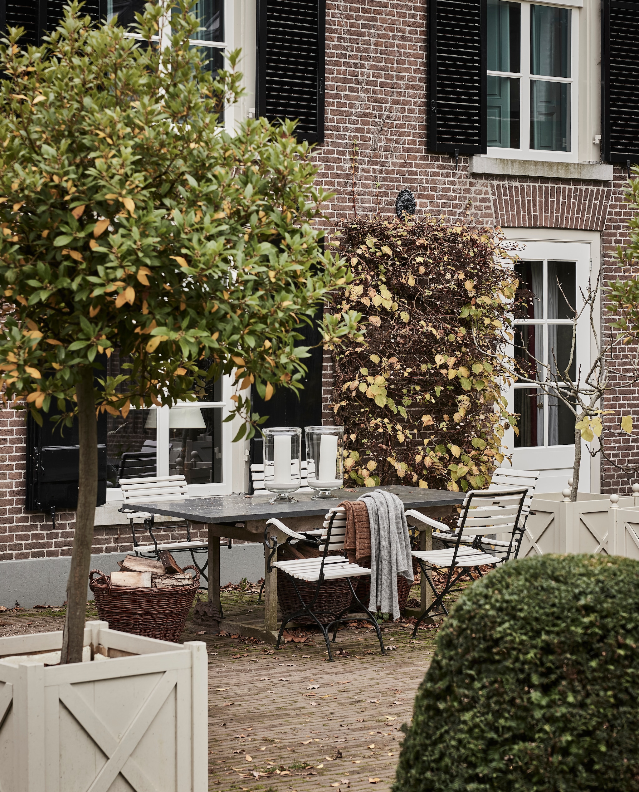 Tuinmeubels Koningdamen. Deken van eigen alpacawol. Windlichten Wilhelmine van Aerssen Agenturen. Rieten manden tuincentrum. vtwonen landelijk 01-2025 | styling Marianne Luning | fotografie Alexander van Berg | tekst Merel van der Lande