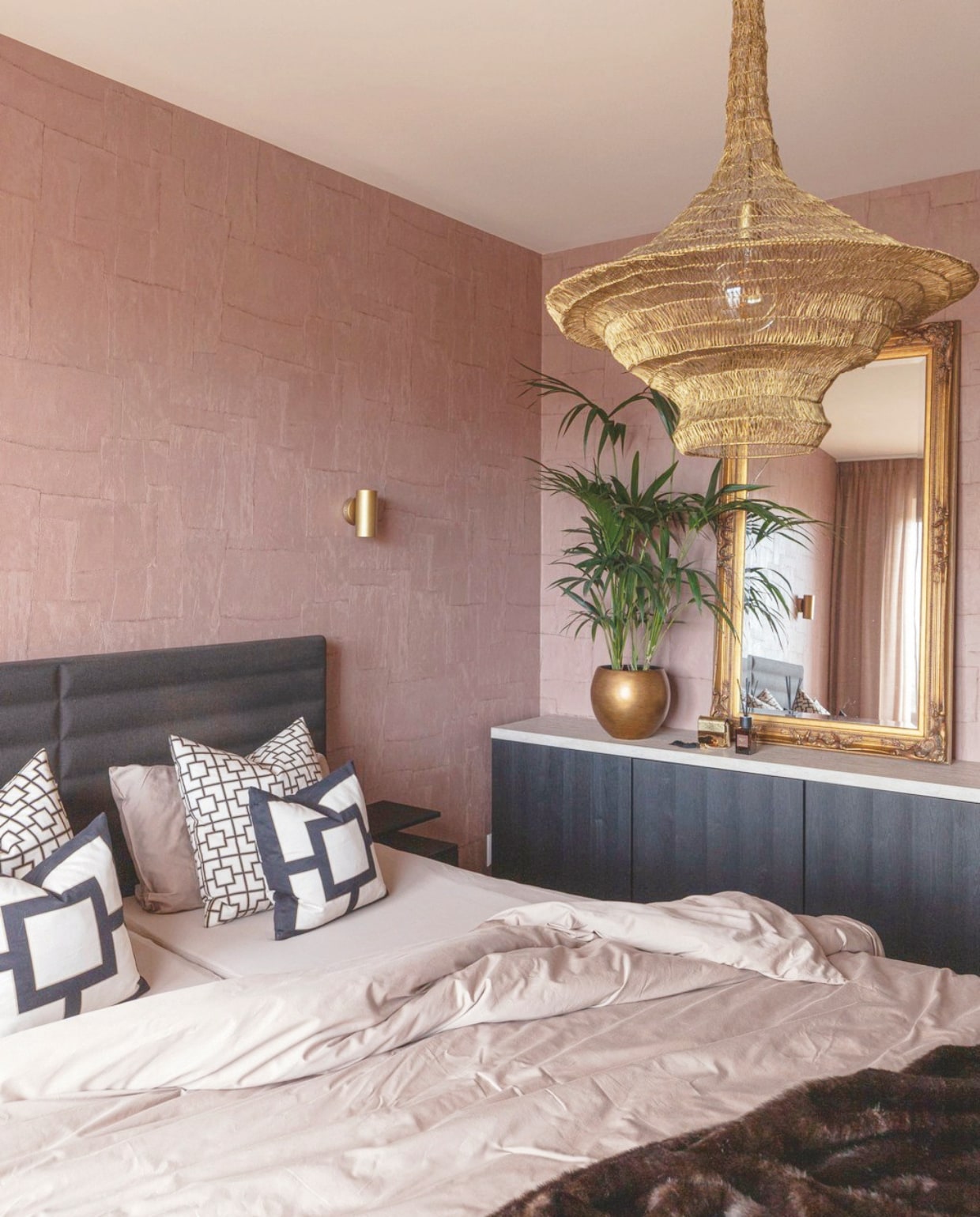 Behang Sculptura Oblong in Soft Terra van Arte. Het bed is gedekt met bedlinnen van Kayori en sierkussens van H&amp;M Home. De hanglamp is van Qazqa, de muurlamp van Karwei. De spiegel is antiek. Het dressoir is van Ikea. stijlvol wonen 07-2024 | productie Taverne Agency | Styling Josephine Visser | Fotografie Chiela van Meerwijk