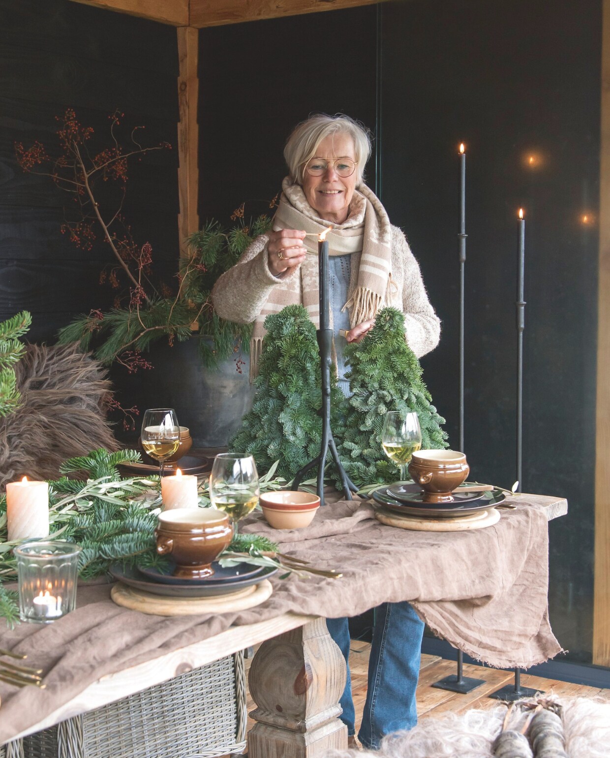 Met een paar takken en kaarsen zorg je gemakkelijk voor een gezellige kerstsfeer aan tafel. vtwonen landelijk 07-2024 | styling Peet! | fotografie Joyce Vloet