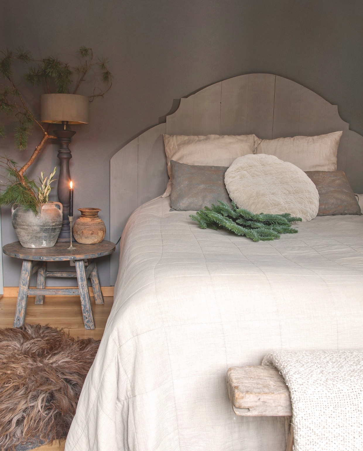 Heerlijk zachte materialen zijn perfect voor in de slaapkamer, zoals een wollen deken, of een schapenvacht op de vloer. vtwonen landelijk 07-2024 | styling Peet! | fotografie Joyce Vloet