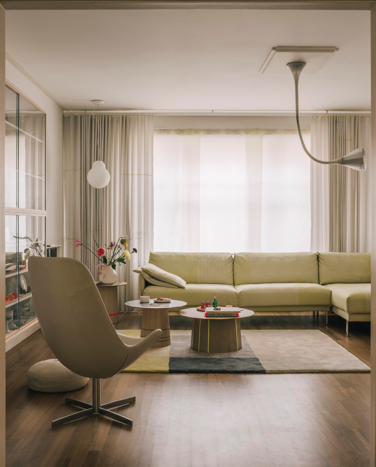 De zitkamer staat vol eigen werk; alle producten zijn ontworpen door Scholten &amp; Baijings. De bank is van Gelderland, de houten bijzettafels zijn Colour Wood Tables voor het Japanse Karimoku New Standard, het vloerkleed is ontworpen voor Hay. De witte glazen lamp is een ontwerp voor Established &amp; Sons. Plafondlamp Pipe is van de architecten Herzog &amp; de Meuron voor Artemide. stijlvol wonen 08-2024 | fotografie Katoo Peeters | tekst Tanne Donjacour Gielen