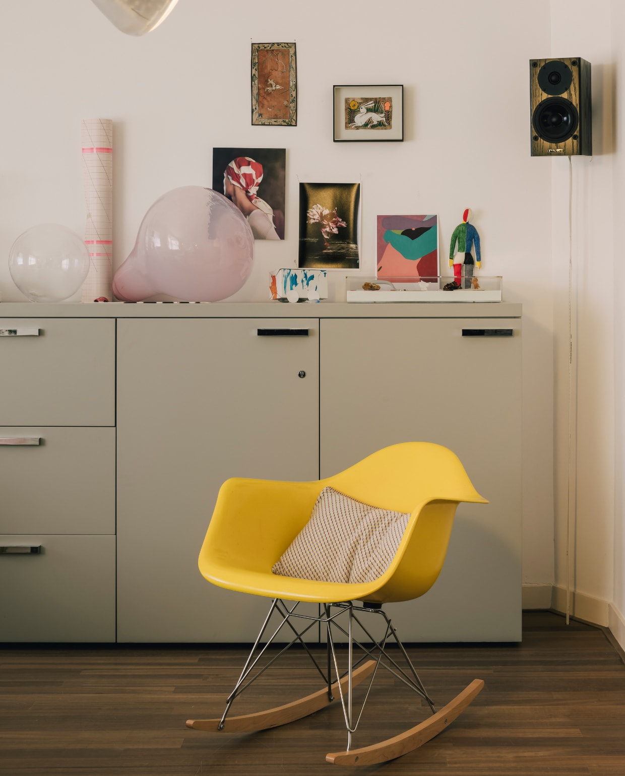 Dressoir van Cappellini met daarop werk van onder anderen Bernard Heesen. De schommelstoel is van Charles &amp; Ray Eames via Vitra. Het gebreide kussen, Grid Knit, is ontworpen voor het TextielMuseum. stijlvol wonen 08-2024 | fotografie Katoo Peeters | tekst Tanne Donjacour Gielen