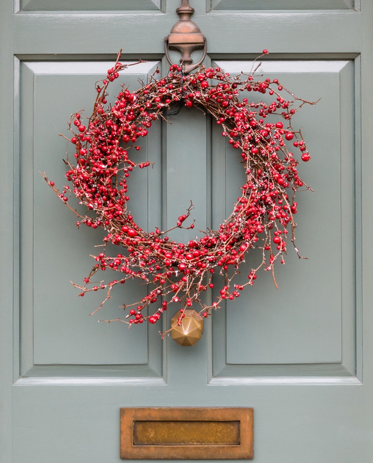 Kerstkrans ophangen aan de voordeur Getty Images