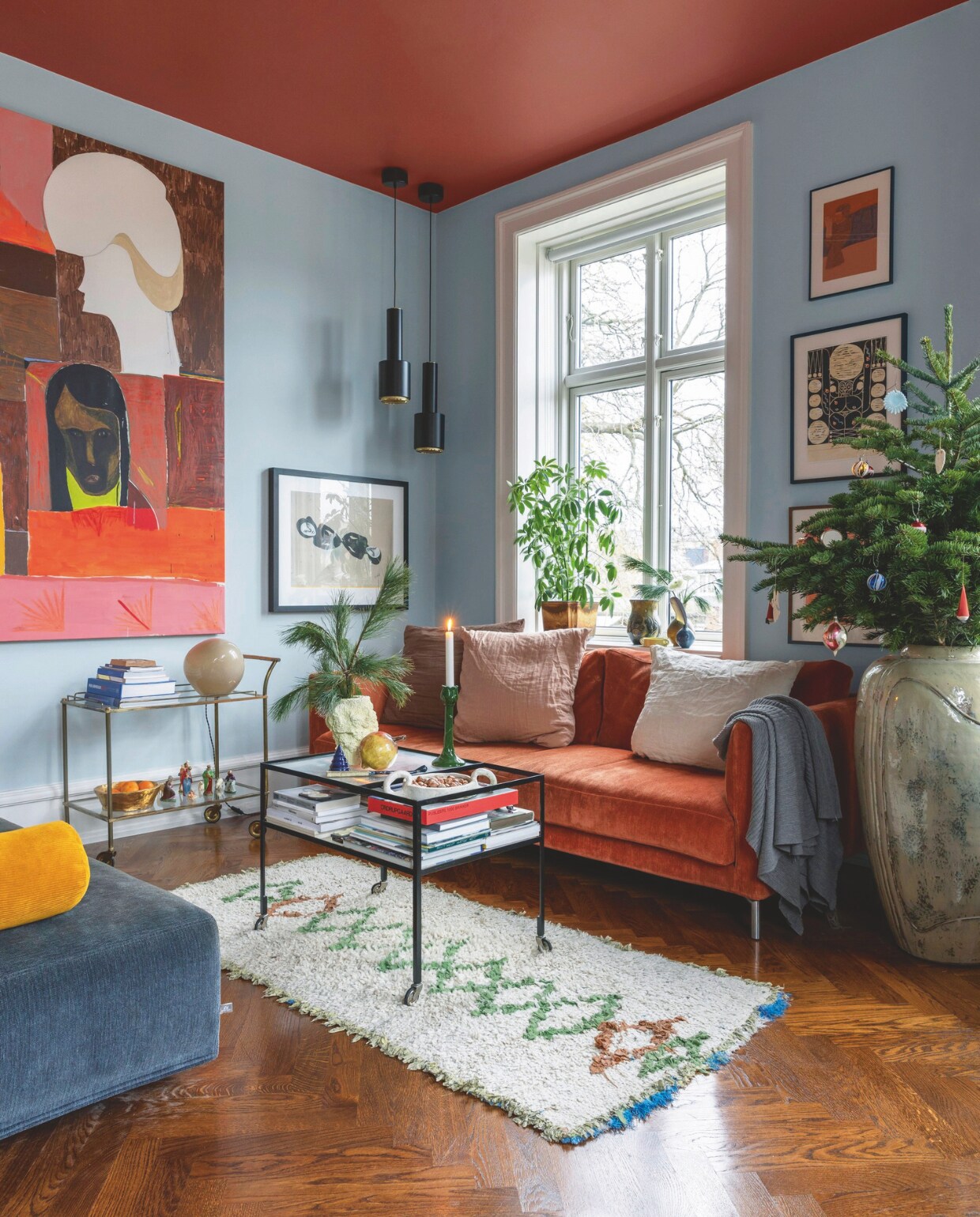 Jette schilderde de wanden in de woonkamer lichtblauw-groen en het plafond sienna terracotta. Banken Eilersen, kussens Merci en Stilleben, Marokkaans vloerkleed By Fribert, salontafel Please Wait To Be Seated, lamp op vintage trolley Helle Mardahl, grote pot Christian Bruun gekocht op Arts and Crafts Market Kopenhagen, hanglampen A110 Hand Grenade van Alvar Aalto gekocht bij Artek, schilderij van Farsjad Farzankia, prints van Cathrine Raben Davidsen, Jan Oksbøll Callesen en Alexander Tovborg. vtwonen 12-2024 | styling Rikke Graff Juel | fotografie Christina Kayser O