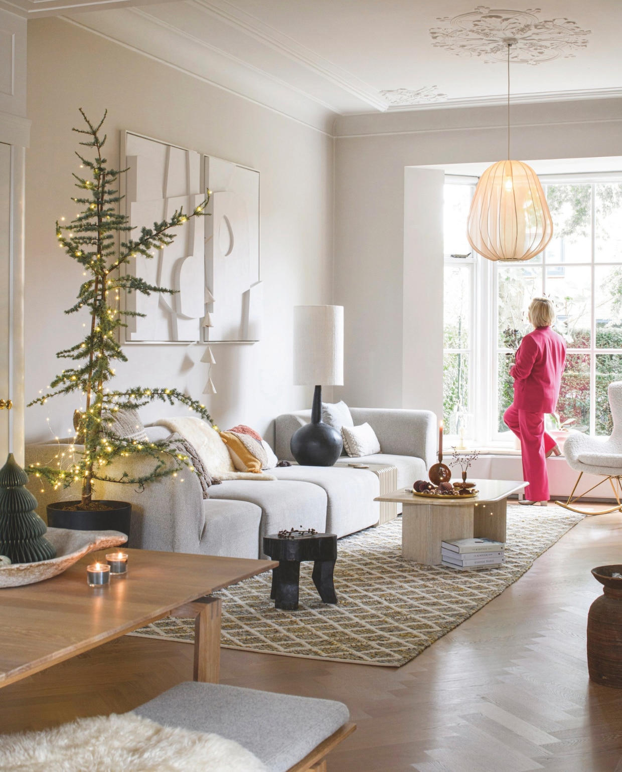 Bank HKliving, salontafel Marktplaats, vloerkleed Sissi-Boy Homeland. Hanglamp, eettafel, bankje en kussen Bolia. Schommelstoel Westwing, tafellamp en krukken Household Hardware, kussens bank H&amp;M Home, Hema, Goround, kandelaars H&amp;M Home, dienblad Hema, kunstwerk Edith Beurskens, boeken Kinfolk. Wandkleur Skimming Stone 241, plafond en kozijnen Strong White 2001 van Farrow &amp; Ball. vtwonen 12-2024 | styling Marit Saladini | fotografie Louis Lemaire