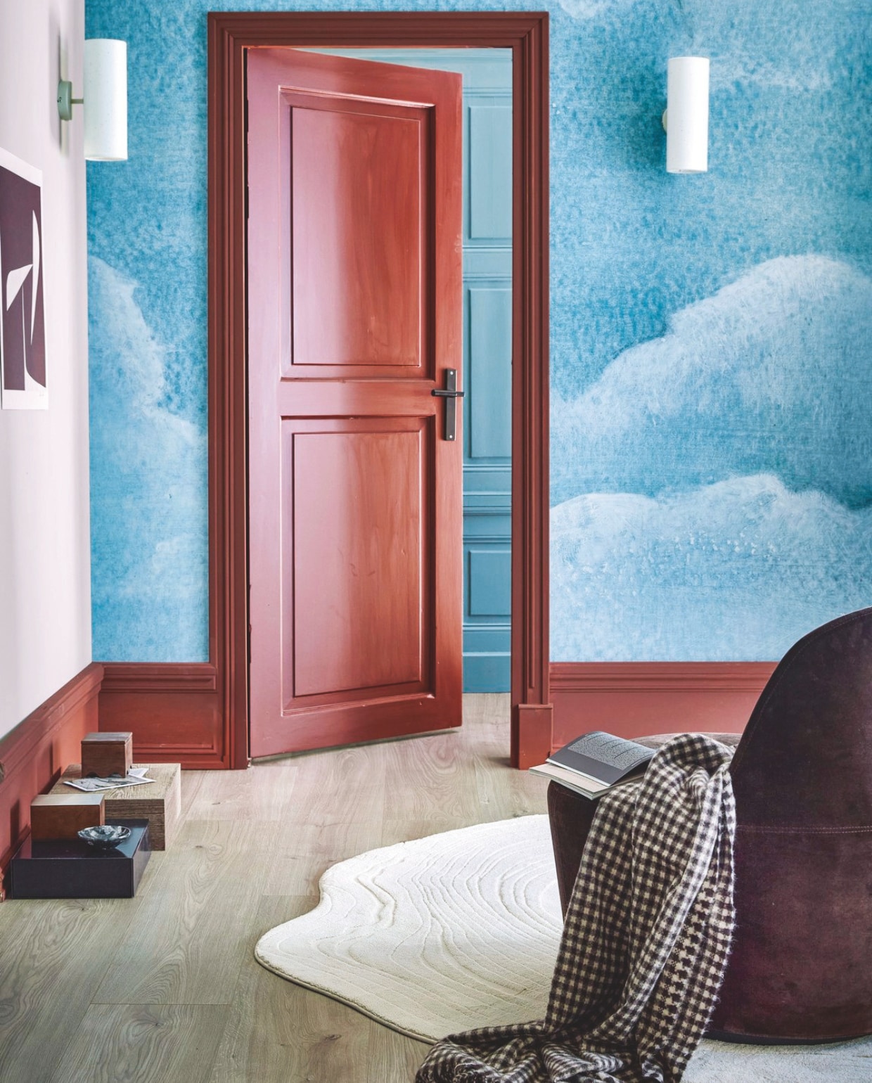 Muurverf krijtmat Light Grey, 1 liter € 27,99. Binnenlak mat Terra, 0,5 liter € 27,99. Fotobehang Cloud, 318x300 cm (bxh) rol (6 banen) € 149,-. Evc-vloer in Oat, inclusief geïntegreerde ondervloer, per lamel 129x24,6x0,5 cm, per m² € 55,99. Polyester vloerkleed Tree Life, 165x180 cm € 159,- en 180x200 cm € 259,-. Papieren wandlamp Paper Tube, 16,5x11x30 cm (bxdxh) € 49,99.M.m.v. designtales.nl (fauteuil Gomo Lounge Chair van Fredericia Furniture), zarahome.com (plaid, houten doos), hay.nl (opbergbox Colour Storage). Overig privébezit. vtwonen 13-2024 | styling Sanne Ketelaar | fotografie Peggy Janssen