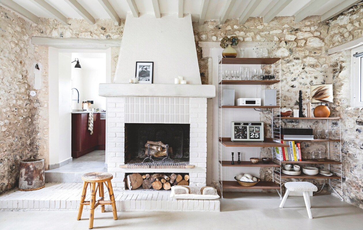 Vloer gepolijst beton, rotan kruk via Selency. Wollen kussen Bed and Philosophy. Muurkleur keuken Natural Rice van Pure &amp; Original, keuken Ikea met op maat gemaakte deuren. vtwonen 13-2024 | styling Marie-Maud Levron | fotografie Yann Deret