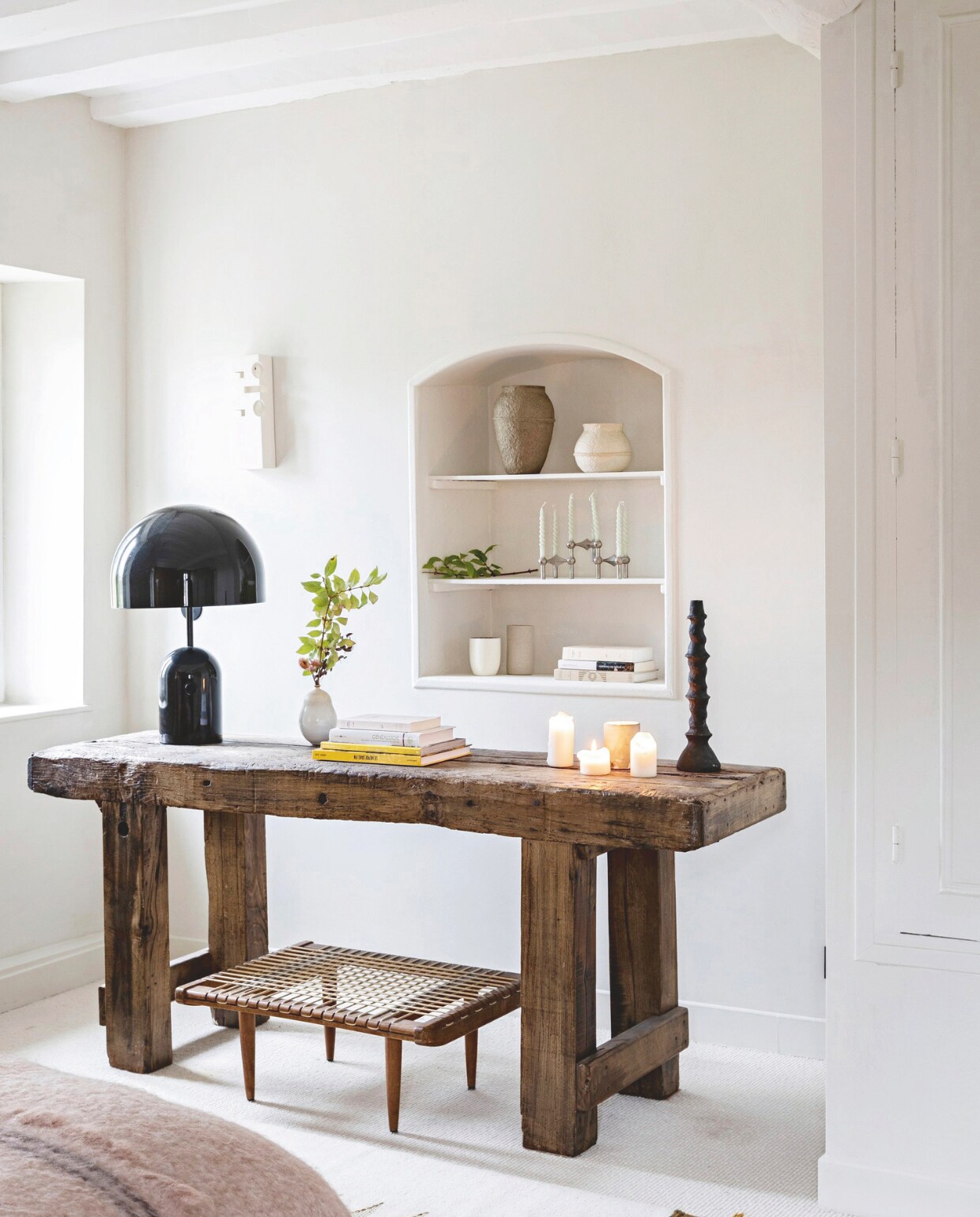 Deken Le Monde Sauvage, kleed Caravane, zwarte lamp Tom Dixon. Wandlamp links van de nis Empreinte van Léa Ginac. Vergelijkbare tafel old-basics.nl, met gevlochten touw Selency. vtwonen 13-2024 | styling Marie-Maud Levron | fotografie Yann Deret
