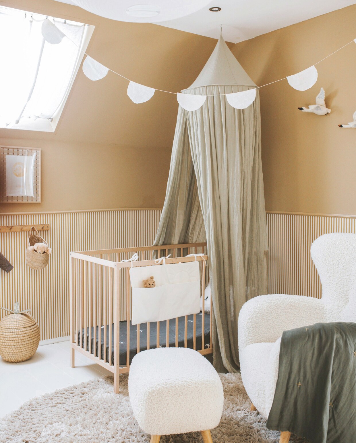 Muurkleur IG KH K-361 van Karwei. Behang Sandberg Wallpaper. Ledikant Ikea. Hemel tweedehands. Bedzakje, slinger en gordijnen zelfgemaakt. Hoeslaken Petite Amélie. Fauteuil Jysk. Zwanen Lidor. Plaid Numero 74. Vloerkleed Karwei. Mand H&amp;M Home. vtwonen binnenkijkspecial 11-2024 | fotografie Merel Annabel Visscher