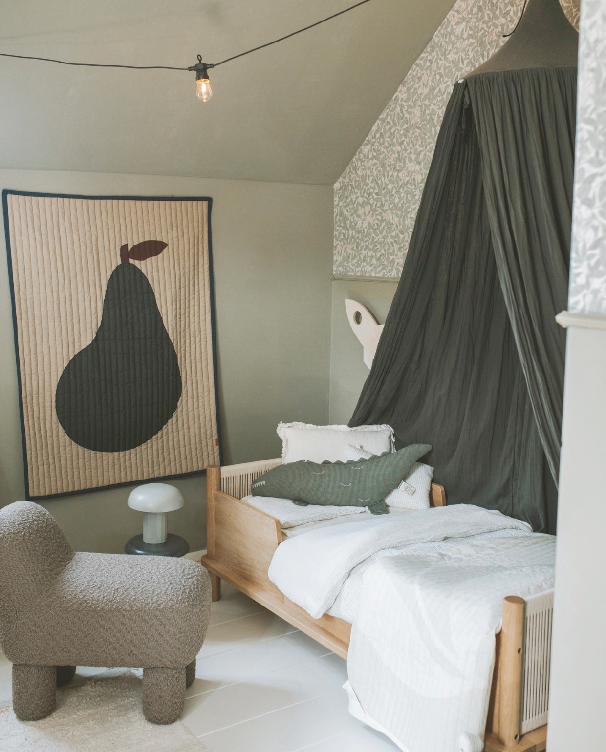 Muurkleur Olive van Fairf. Behang Sandberg Wallpaper. Bed, beddengoed en kussens Nobodinoz. Hemel en kruk tweedehands. Poef Nordic Nest. Wandkleed Ferm Living. Nachtlamp Søstrene Grene. Wandlamp Toddie. vtwonen binnenkijkspecial 11-2024 | fotografie Merel Annabel Visscher