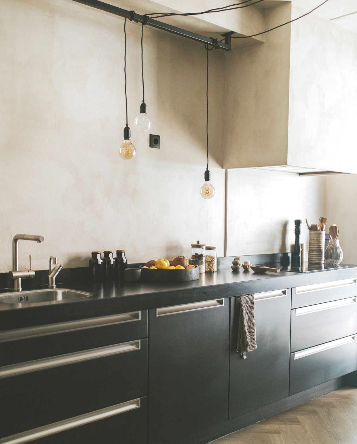 Keuken van Eigenhuis Keukens met gewrapte kastfronten door wrapjekeuken.nl. Lampen Loods 5. Op het aanrecht flessen kruidenthee uit Ibiza, glazen potten Zara Home, vintage West Germany-keramiek via Marktplaats. Muren en spatwand geverfd met kalkverf Mushroom no. 287 van Lab Paint en daarna gesealed, zodat ze waterafstotend zijn. vtwonen binnenkijkspecial 11-2024 | fotografie Merel Visscher