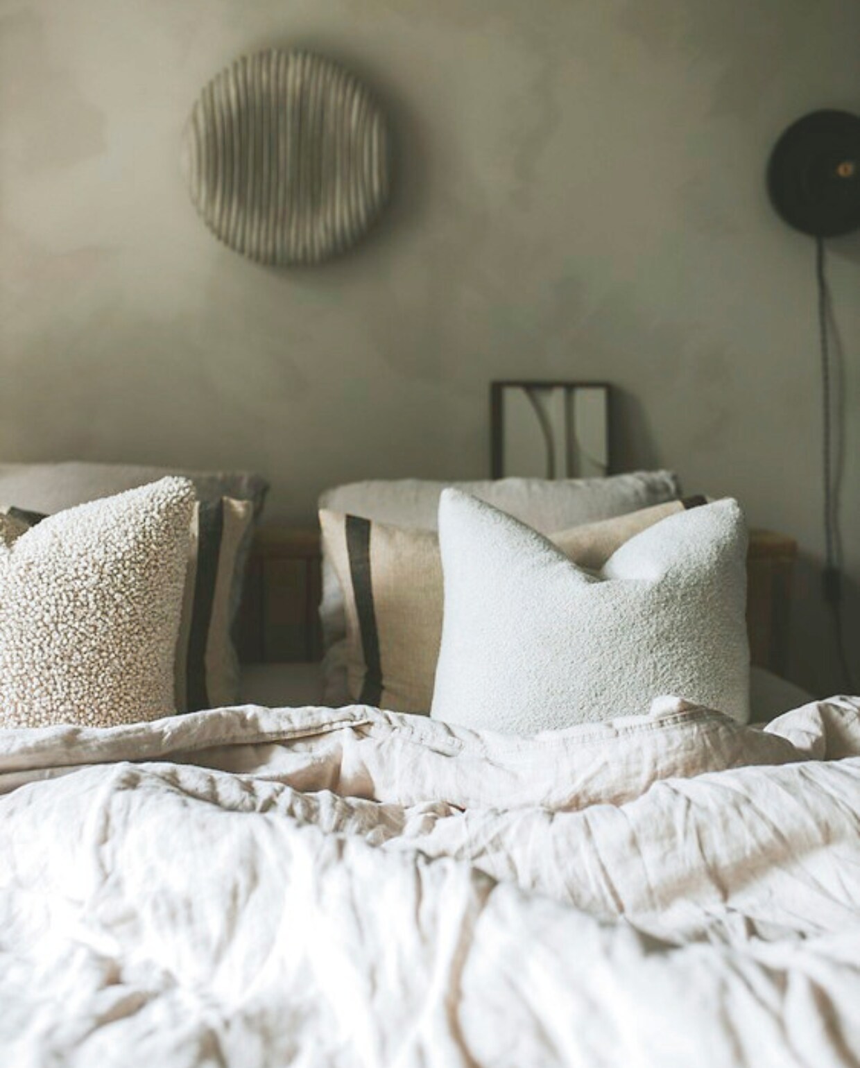 Bouclé kussenhoezen Zara Home. Hoezen met print en linnen dekbed H&amp;M Home. Rond kunstwerk Studio Astrid Dodd. vtwonen binnenkijkspecial 11-2024 | fotografie Merel Visscher