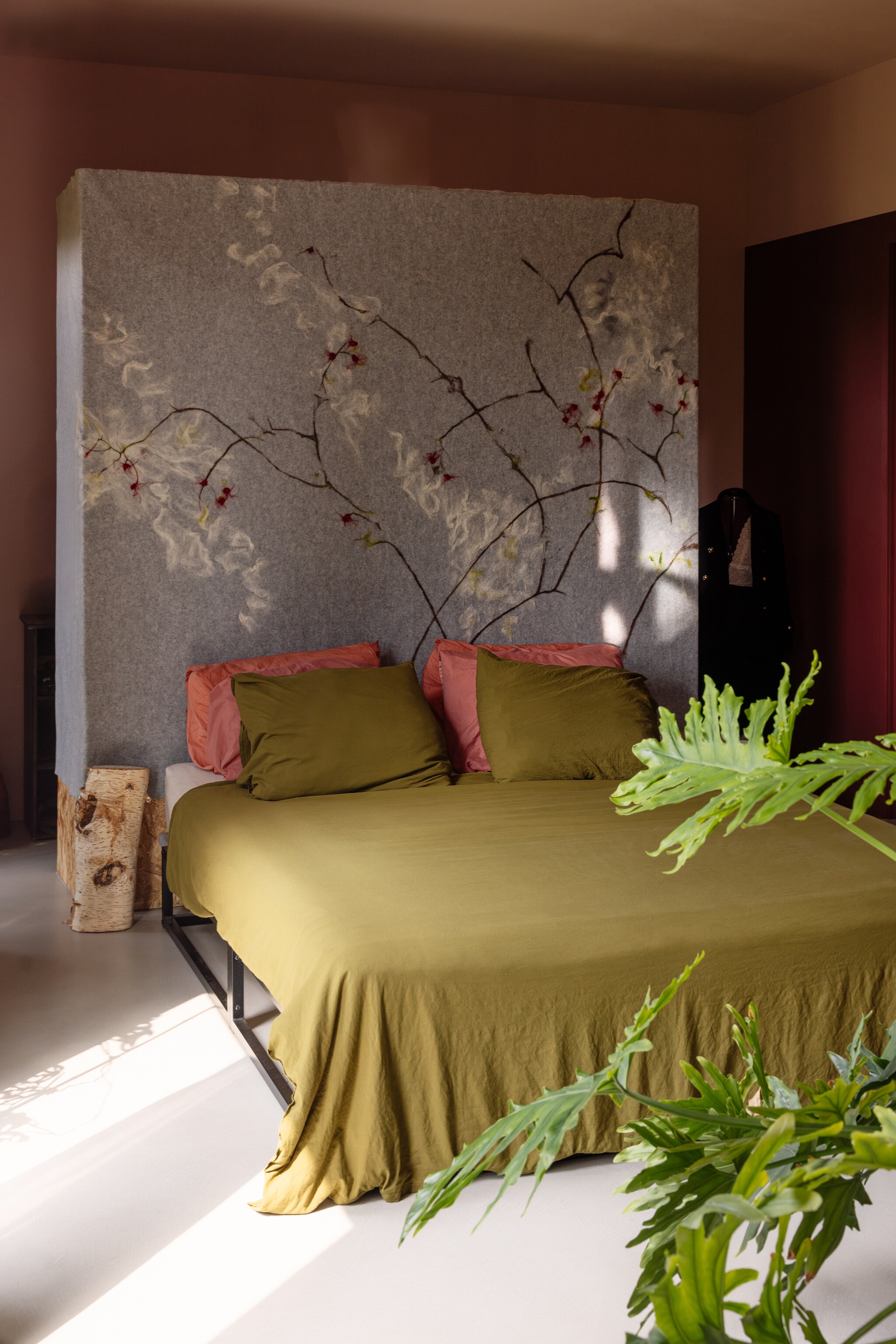 Gietvloer met microtopping M2 Vloeren, viltwand, muurkleur Interieur van Gamma, bedframe VidaXL, beddengoed Dekbed Discounter, bijzettafel van berkenstam uit eigen tuin, plant Philodendron Selloum. vtwonen 02-2025 | styling ilona jongepier | fotografie dana van leeuwen | tekst Mirjam Rosema-Verhulst
