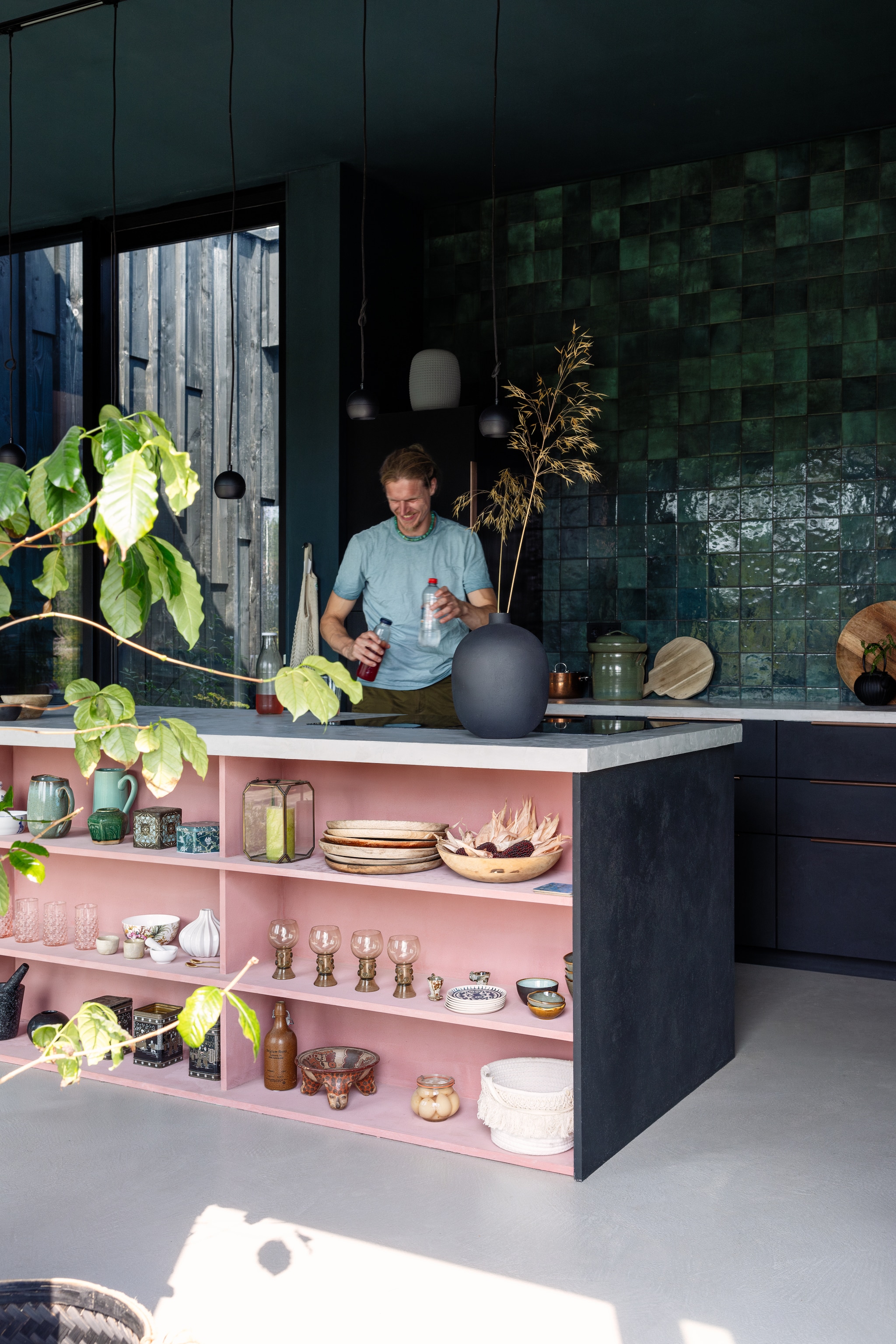 Tegels Tegels in Huis, kleur houtwerk matzwart met structuur. DIY-keuken met Ikea-kasten als basis. Roze verf Chalkwash in Terracotta van Rust-Oleum, lampen in railsysteem Renko van Arcchio, witte vaas Jysk, houten borden Mica Decorations. Bovenste plank: schaaltjes Anouk Kramer, kan en windlicht Intratuin. Tweede plank: waterglazen Anna von Lipa, Roemer wijnglazen vintage. Onderste plank: mand Xenos, luipaardschaal Wereldwinkel. vtwonen 02-2025 | styling ilona jongepier | fotografie dana van leeuwen | tekst Mirjam Rosema-Verhulst