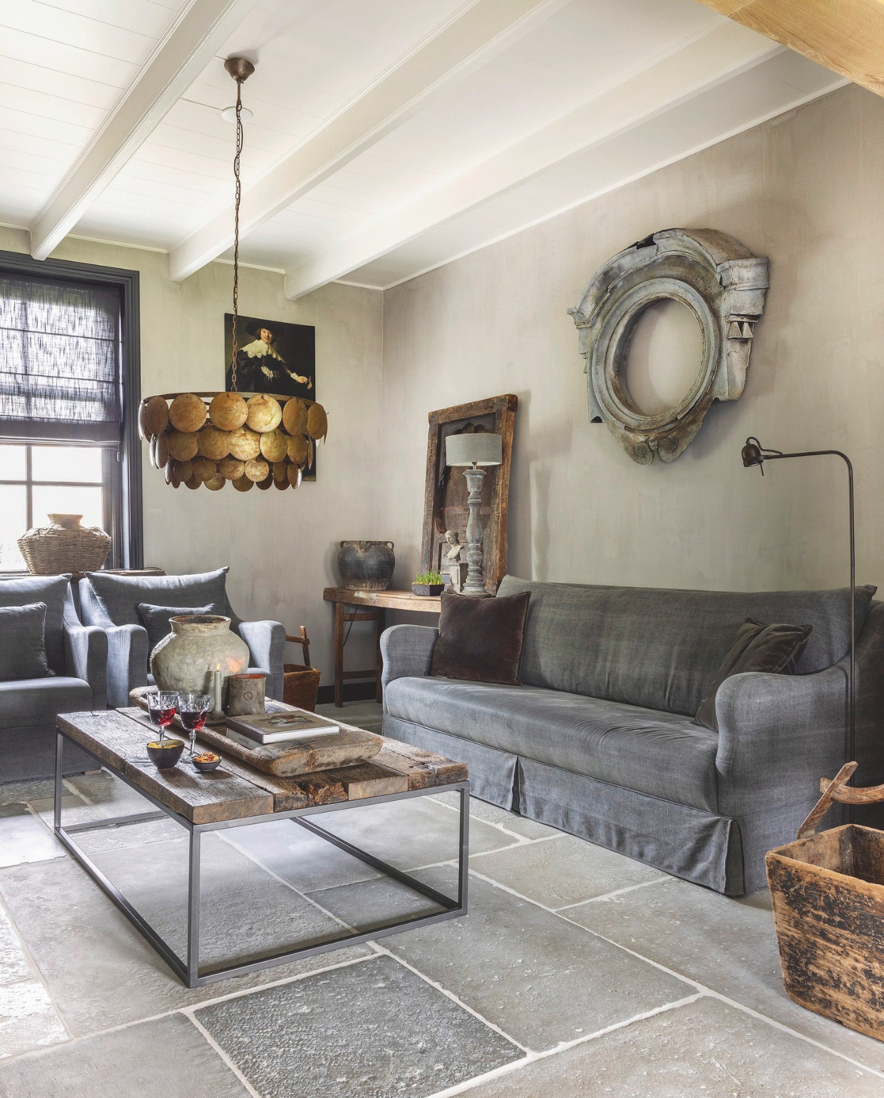 Bank, stoelen en Raw Stones op de vloer Rust &amp; tiek. Het ossenoog aan de muur via Marktplaats. vtwonen landelijk binnenkijkspecial 2024 | fotografie Anneke Gambon
