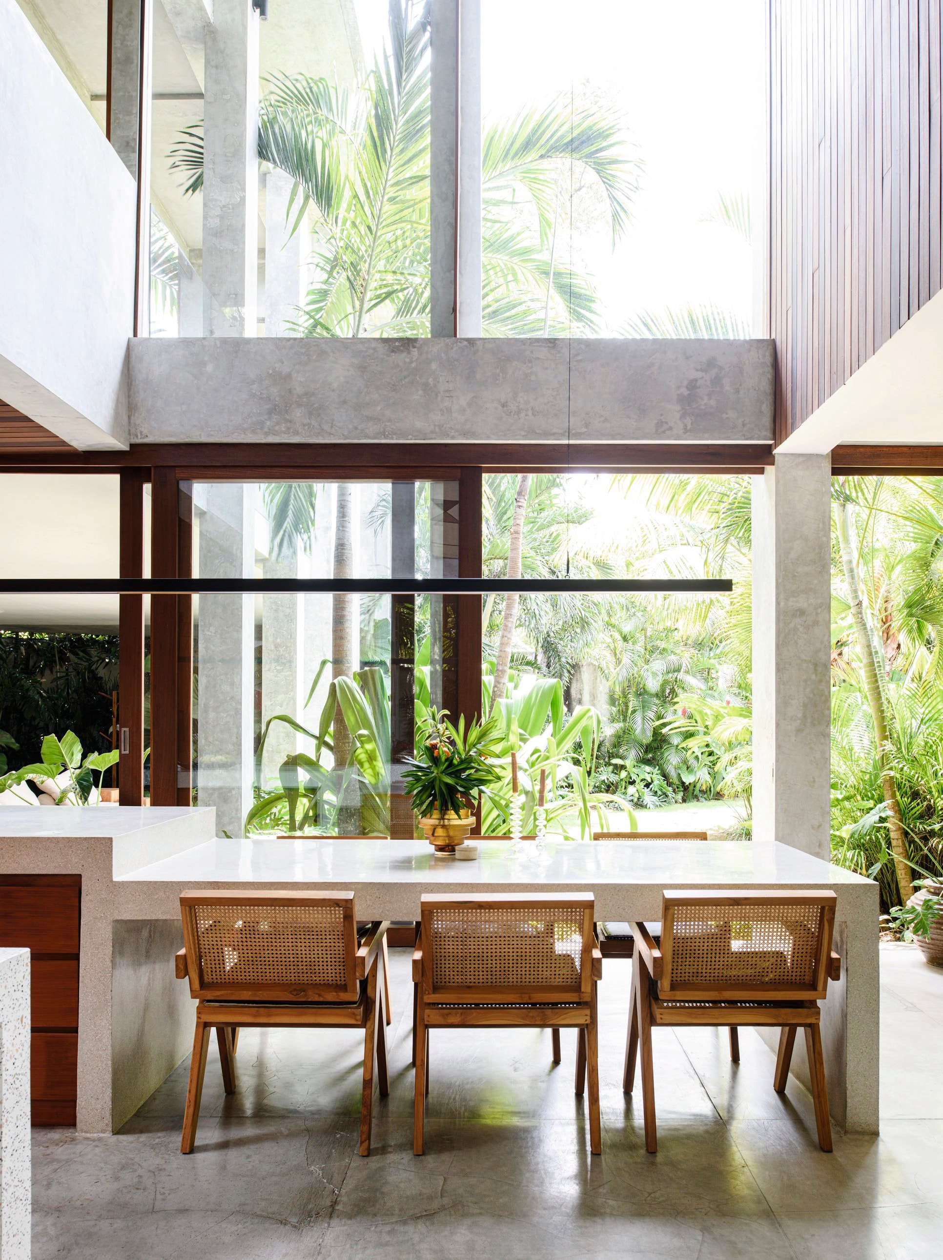 Stoelen Chandigarh van Pierre Jeanneret. Tafel van gepolijst beton. vtwonen 03-2024 | styling kim timmerman | fotografie louis lemaire