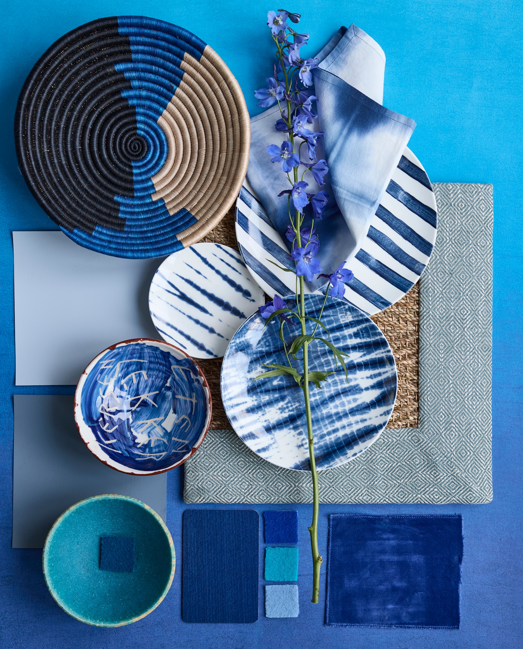 Aquablauw bord en schaal met letters Unica van Polspotten x Norman Trapman € 45 (polspotten.com). Porseleinen borden Tie-Dye van vtwonen, vanaf € 5,95, katoenen servet Tie-Dye van vtwonen, set van 2 € 12,95 en sisal wandschaal Shoreline van Maison Suku€ 34,95 (shop.vtwonen.nl). Stalen: behang Saraille Cobalt van Designers Guild, 300x45 cm (lxb) per rol € 449,- (wva.nl). Zeegras vloerkleed met gerecycled katoenen randafwerking, prijs op aanvraag (cunera.nl). Wollen stalen van plaids (aabe.nl). Kalkverf Blue Bay, 1 liter € 66,- en binnenlak Denim van Lab Paint, 500 ml € 51,- (vestingh.nl). vtwonen 4-2025 | styling Marianne Luning | fotografie Alexander van Berge