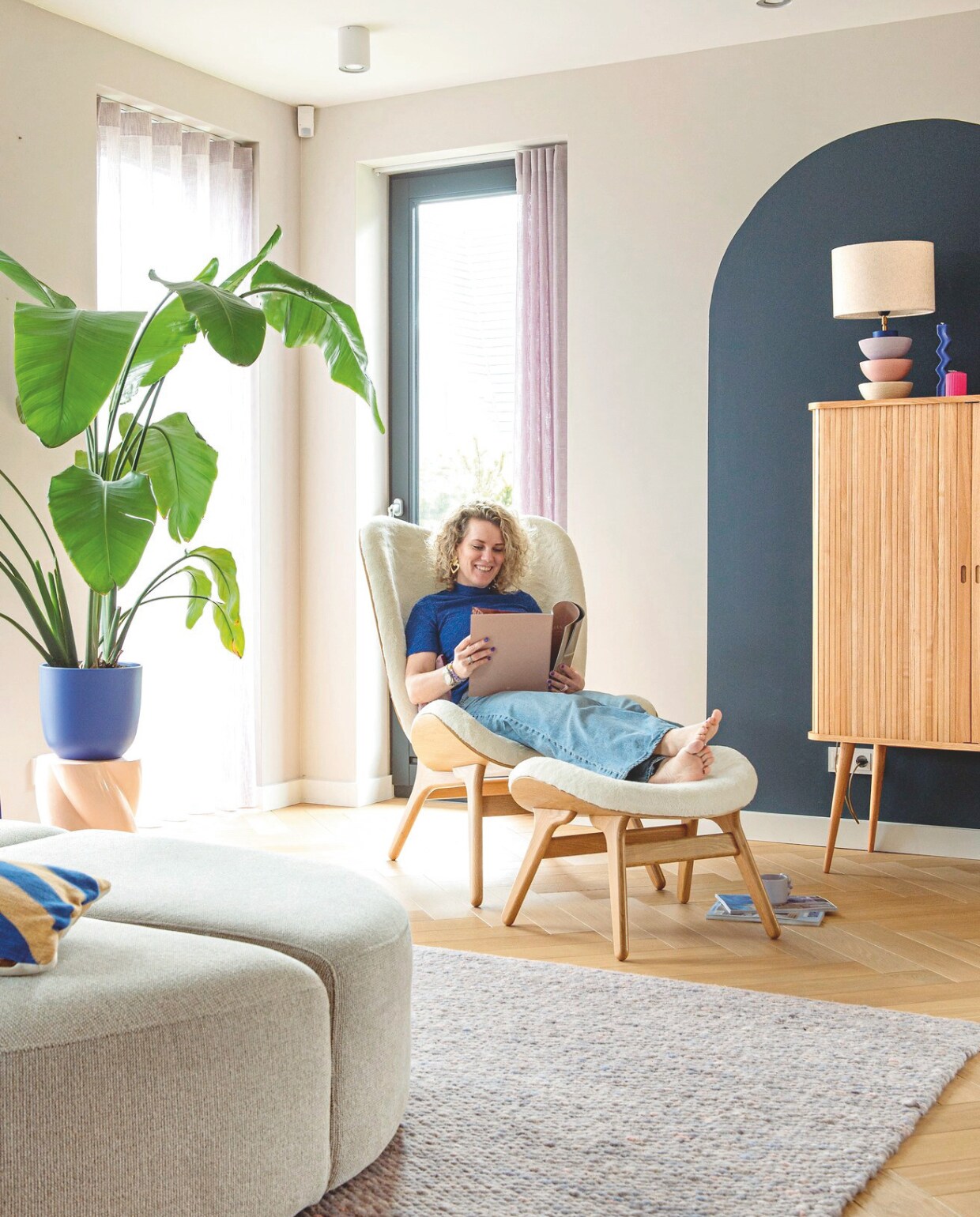 Ligstoel met hocker Umage. Kleed Perletta. Houten kast Zuiver. Lamp Maud Woltman. Kaarsen souvenir Barcelona. Muurverf Skimming Stone en Hague Blue van Farrow &amp; Ball. Lila gordijnen Vadain. Roze bijzettafel &amp;klevering. Plantenpot geschilderd in kleur Orca Song van Histor. Gestreept kussen Oyoy. vtwonen binnenkijkspecial 11-2024 | styling Jeske Weel | fotografie Caroline Coehorst