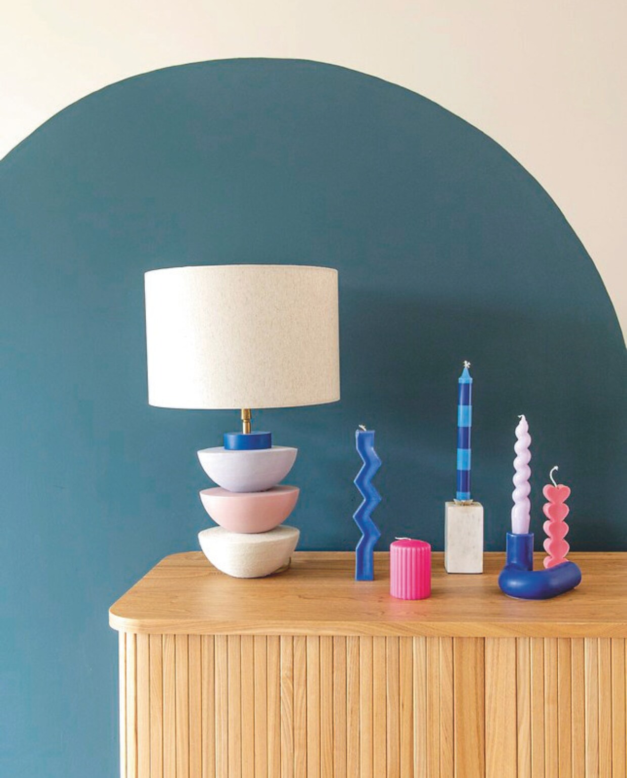 Lamp Maud Woltman. Vaas met gestreepte kaars kringloop. Blauwe kandelaar Octaevo. Kaarsen Hema, Hay en souvenir uit Barcelona. vtwonen binnenkijkspecial 11-2024 | styling Jeske Weel | fotografie Caroline Coehorst