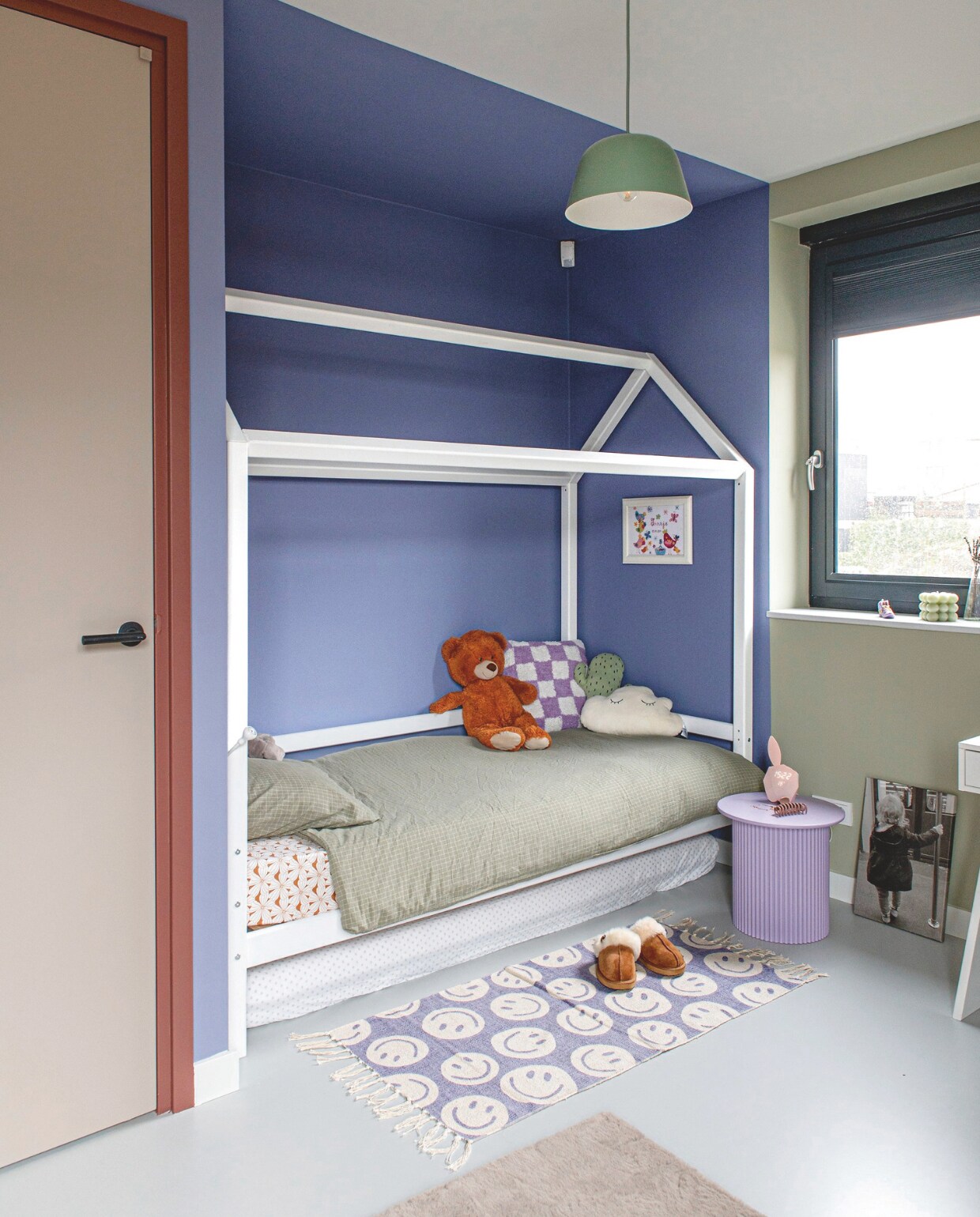 Bed Woood. Kleed Kwantum. Lamp Muuto. Lila nachtkastje Xenos. Kussens: geblokt By-Boo, cactus Oyoy, wolk cadeau. Ingelijst borduurwerk zelfgemaakt. Portret zelf geprint. Muurverf Violet Verbena en Pine Crush van Histor My Color. vtwonen binnenkijkspecial 11-2024 | styling Jeske Weel | fotografie Caroline Coehorst