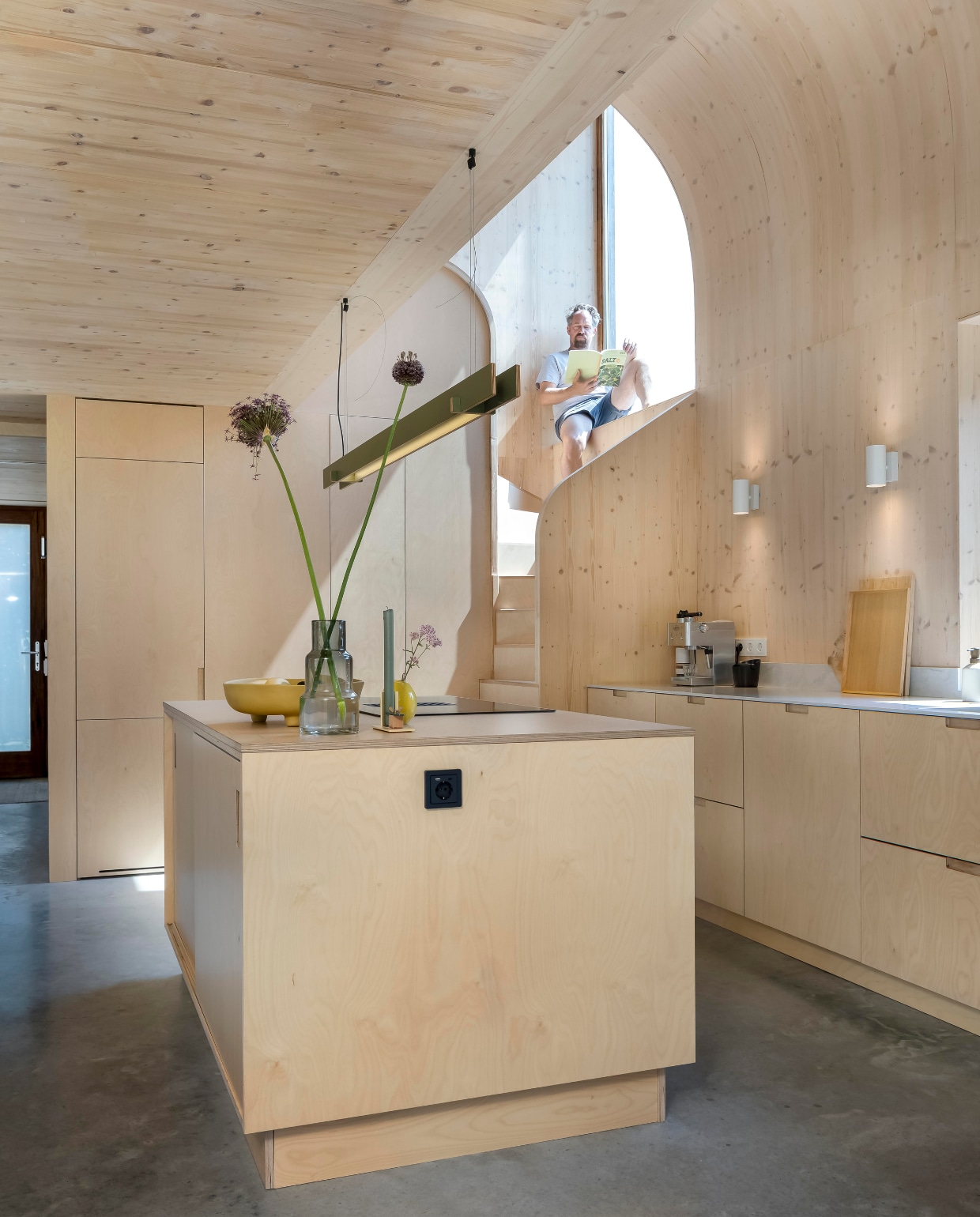 De rondingen in het trapgat volgen die van het plafond. Dankzij de dikte van de gevelconstructie waren er diepe vensterbanken mogelijk. Veel tussenwanden hebben ingebouwde kasten. Hele interieur inclusief keuken Wel Interieurs, werkblad Himacs Aurora Grey van Baars &amp; Bloemhoff. Schaal Loods 5, geel vaasje Des Pots, grote vaas cadeau, kandelaar Floris Hovers, hanglamp Tube van Kilo, witte spots Ikea, zwart stopcontact Berker Q1, gietvloer van gevlinderd beton. vtwonen 01-2025 | fotografie Hennie van Belkom