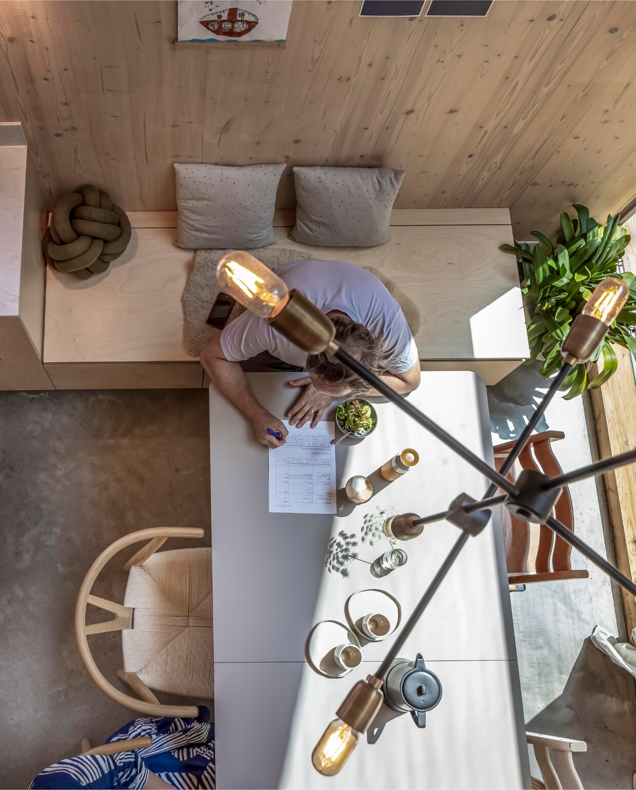 De aanrechtkasten lopen door in de eetkamerbank, ook met opbergruimte. Knoopkussen Design House Stockholm. Kussens Ikea, H&amp;M Home en Zara. Tafel &amp;Tradition via Edwin Pelser, borden Marjoke de Heer, mokken uit Japan, theepot Bredemeijer, hanglamp House Doctor, stoelen Loods 5. vtwonen 01-2025 | fotografie Hennie van Belkom