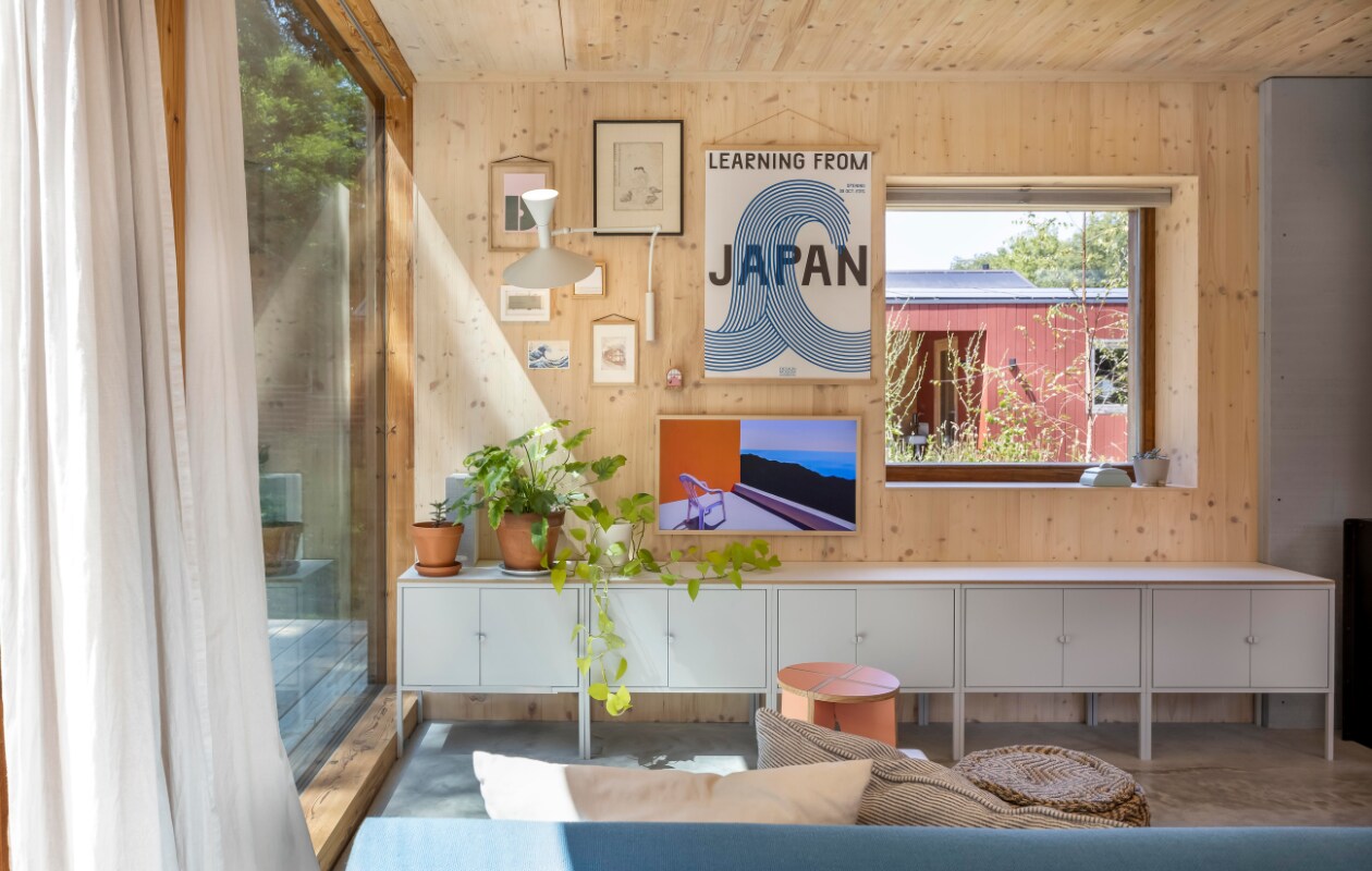 Arnout en Marieke bouwden zelf het bijgebouw, dat net als het huis met Zweedse Falu Rödfärg is afgewerkt. Verf Träfasad Pure Paint, kasten Ikea, poster Designmuseum Danmark, kaarten Carla Nederbragt, ets zelfgemaakt, keramische pot erfstuk, tv Frame van Samsung, Lamp Marseille mini van Le Corbusier via Edwin Pelser, roze kruk Kilo, poef uit India. Kussens Ikea, H&amp;M Home, Zara. vtwonen 01-2025 | fotografie Hennie van Belkom