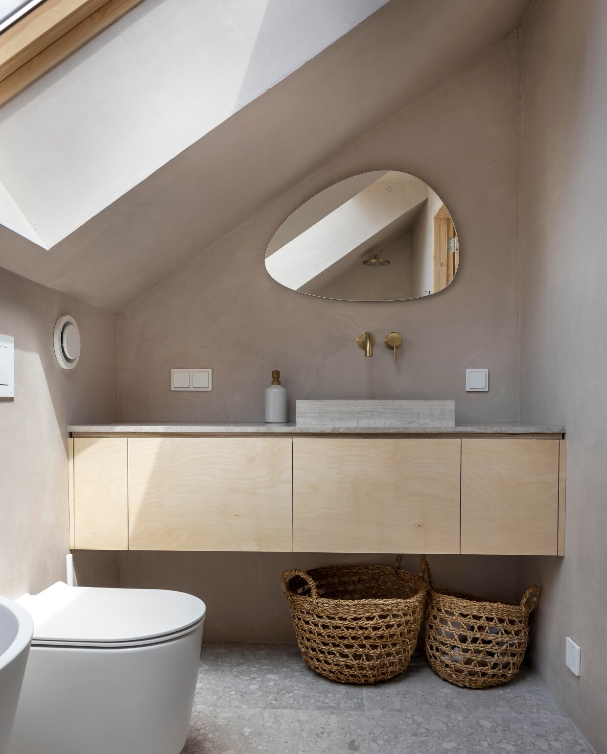 Spiegel Quality Heating, kraan Wiesbaden. Marmeren blad en waskom Furnified. Vloertegels vtwonen, wanden beton ciré Wel Interieurs, manden H&amp;M Home. vtwonen 01-2025 | fotografie Hennie van Belkom