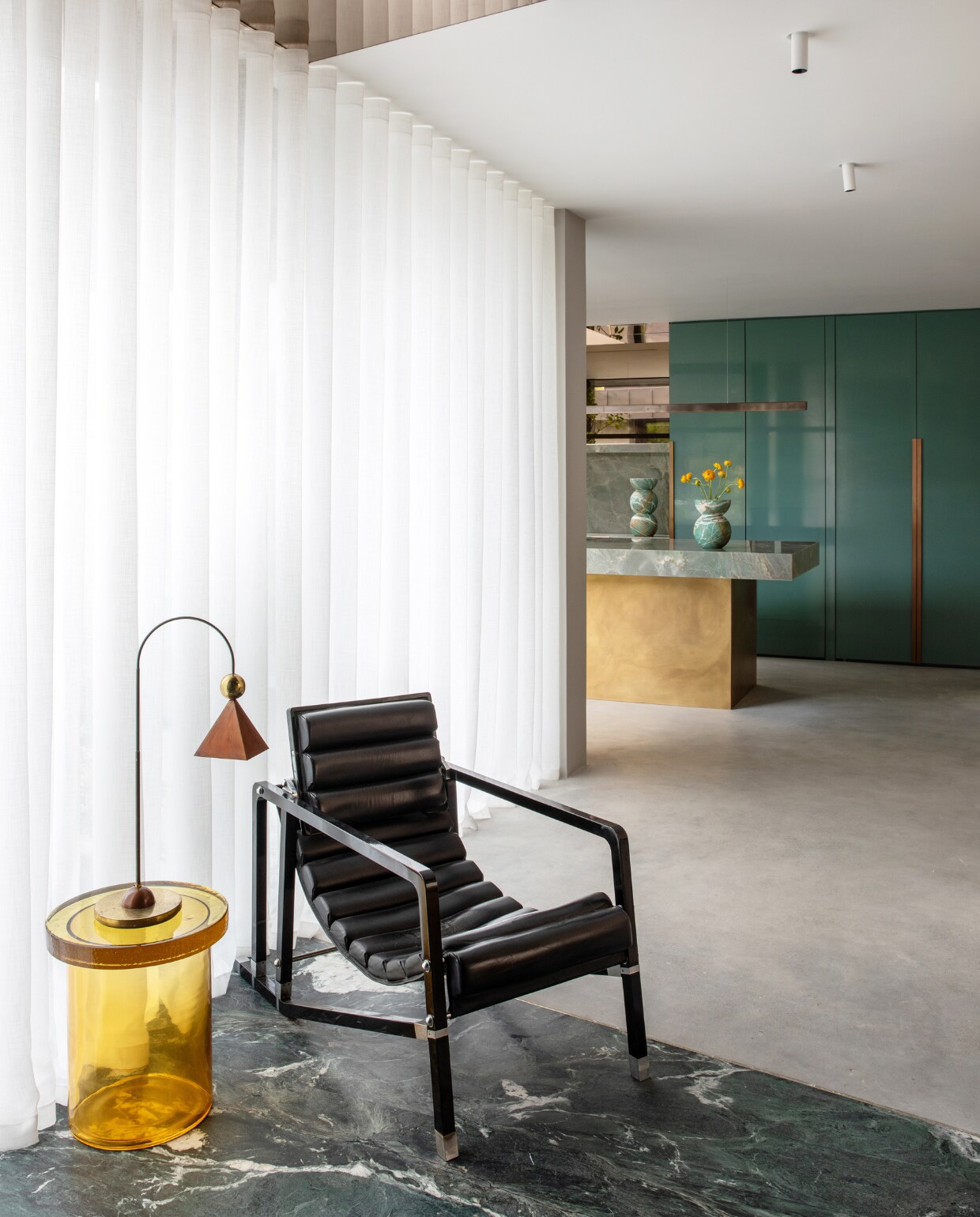 De keuken loopt over in de centrale zitruimte. Loungestoel Transat van Eileen Gray, bijzettafel Alwa Three in Amber van Pulpo,  vintage tafellamp via Acquired. stijlvol wonen 01-2025 | productie Living Inside | fotografie Ruth Maria Murphy