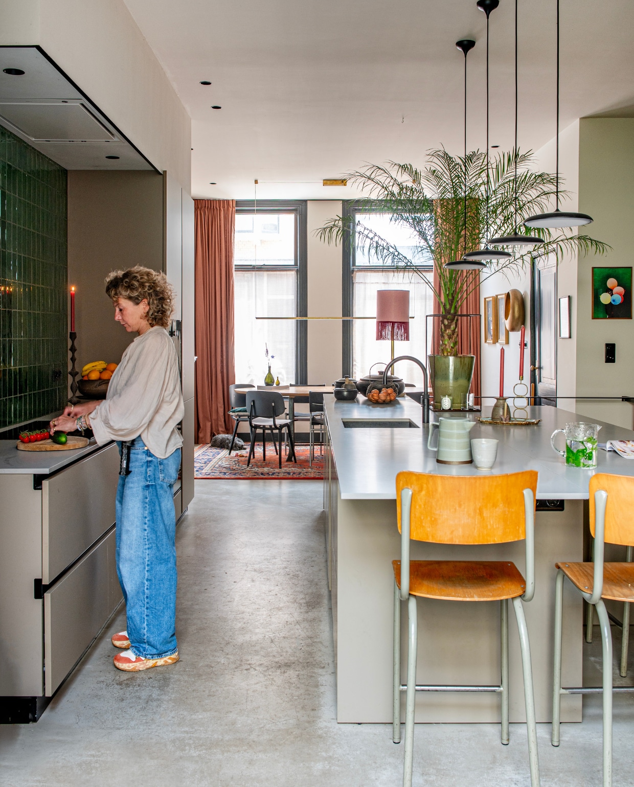 Keuken, wandtegels Kol van Intercodam. Kraan Quooker. Krukken, kandelaars kringloopwinkel, hanglampen Flos, theepot Broste Copenhagen, mok Lilo Ceramics Studio, karaf Iittala, kunstwerk rechts Derrick Ofosu Boateng, schemerlamp Madame Garage, stoelen Revolt van Friso Kramer heruitgebracht door Hay, vloer beton. Verfkleur plafond Skimming Stone, muur rechts Card Room Green en kozijnen Off-Black van Farrow &amp; Ball. vtwonen 01-2025 | productie De Binnenkijkers | fotografie Caroline Coehorst