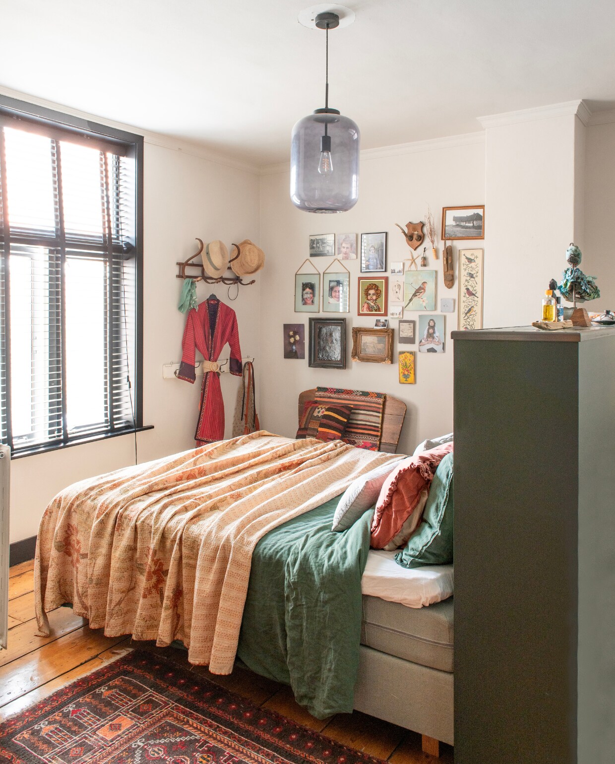 Beddengoed Suite702, lamp Karwei, raambekleding raamdecoratie.com, kapstokken kringloop, Perzisch tapijt uit ouderlijk huis, aan de muur werkjes met een persoonlijke waarde, muurverf Skimming Stone van Farrow &amp; Ball. vtwonen 01-2025 | productie De Binnenkijkers | fotografie Caroline Coehorst