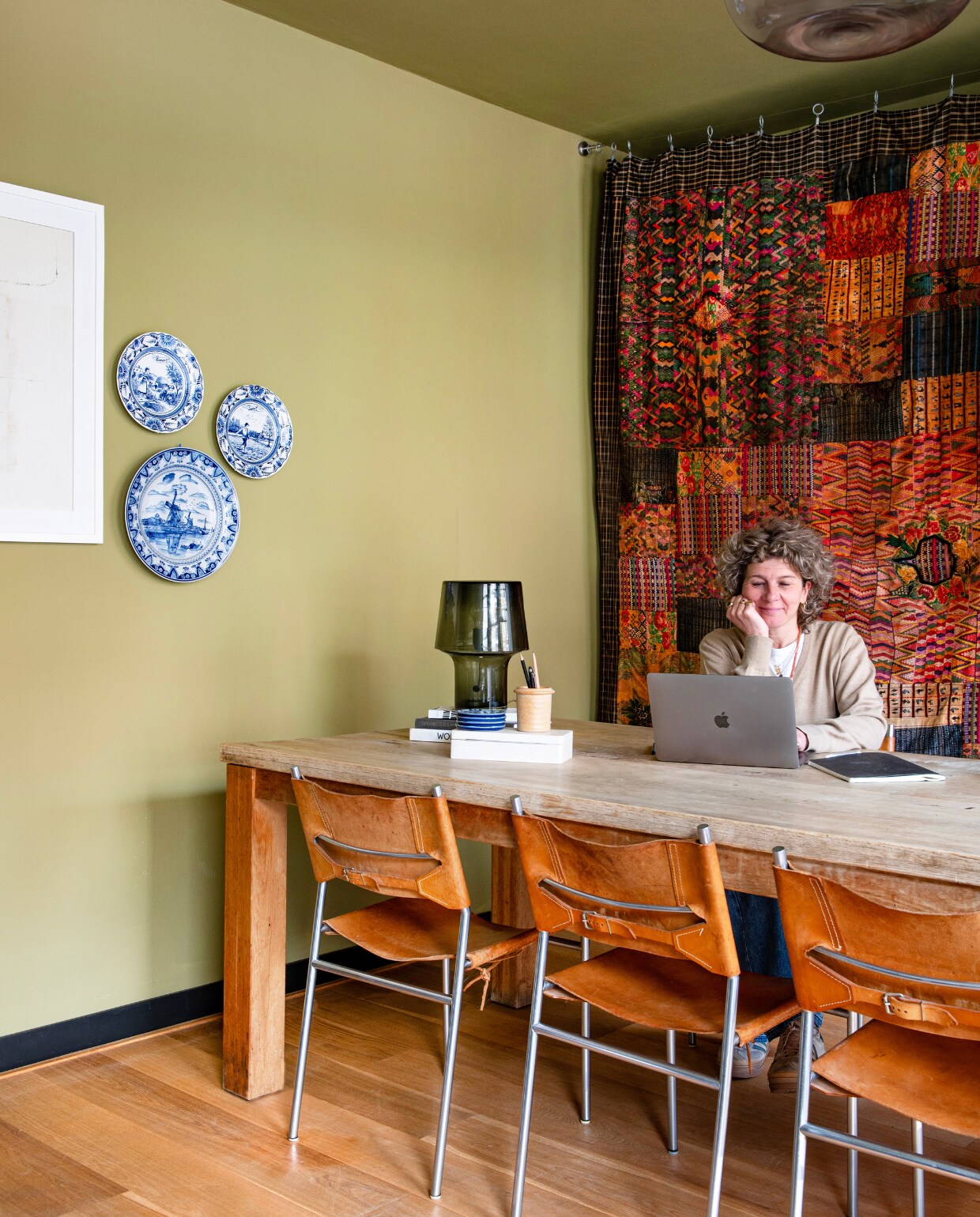 Delfts Blauw en pennenpot kringloop. Tafellamp Muuto, de werktafel was de eettafel toen de kinderen nog thuis woonden, stoelen van Martin Visser uit ouderlijk huis van Rogier, gordijn op veiling gekocht, hanglamp Karwei, vloer eikenhout. vtwonen 01-2025 | productie De Binnenkijkers | fotografie Caroline Coehorst