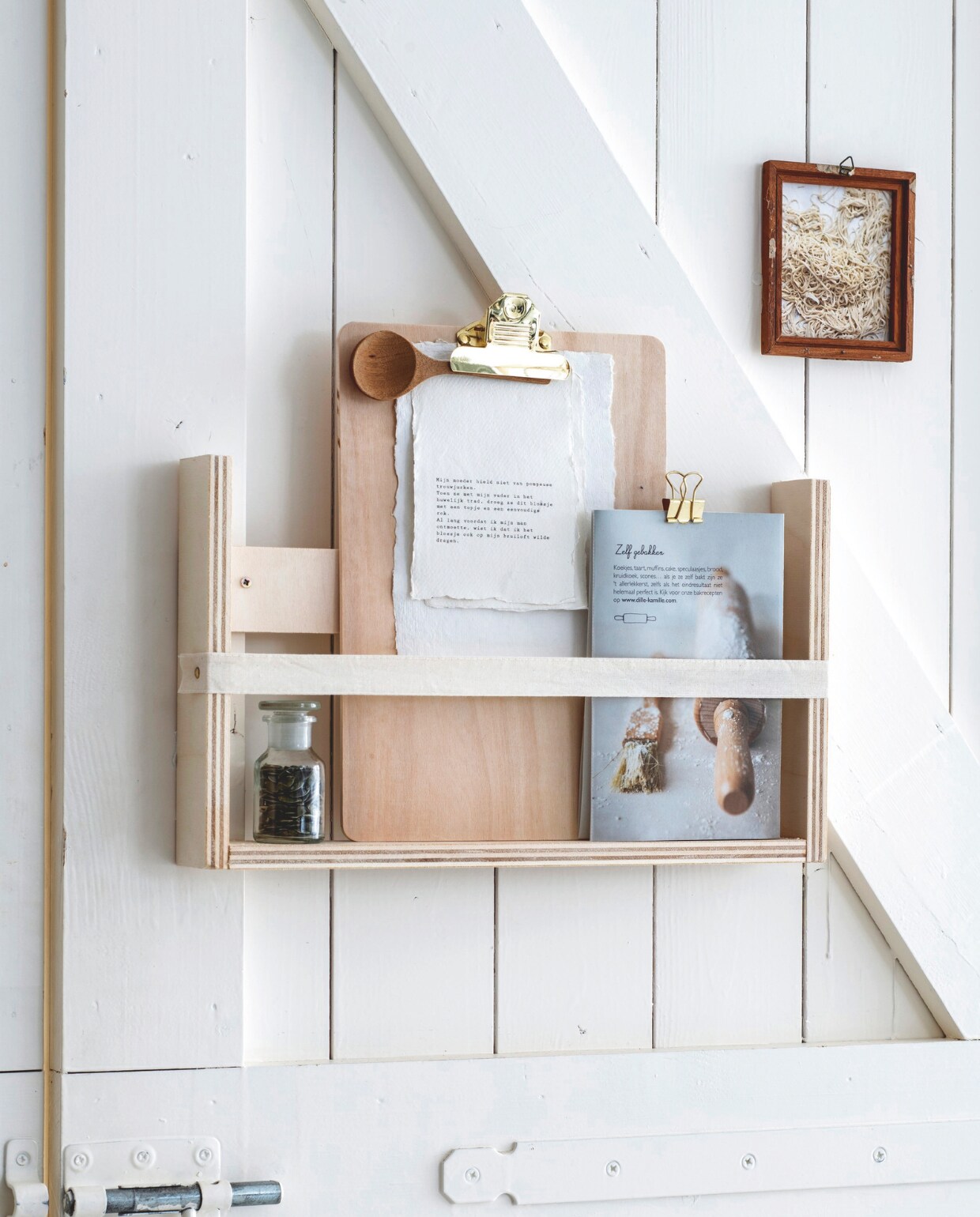 DIY - pronkplank, Glazen apothekerspot, 6x11 cm (Øxh) € 4,50 (dille-kamille.nl). Mangohouten lepel € 9,99 (hm.com). Papierclip € 1,50 (stationerygift.nl). Houten klembord A4 met butterflyclip € 4,78 (papierklem.nl). vtwonen 1-2025 | styling Myla Griese | fotografie Louis Lemaire