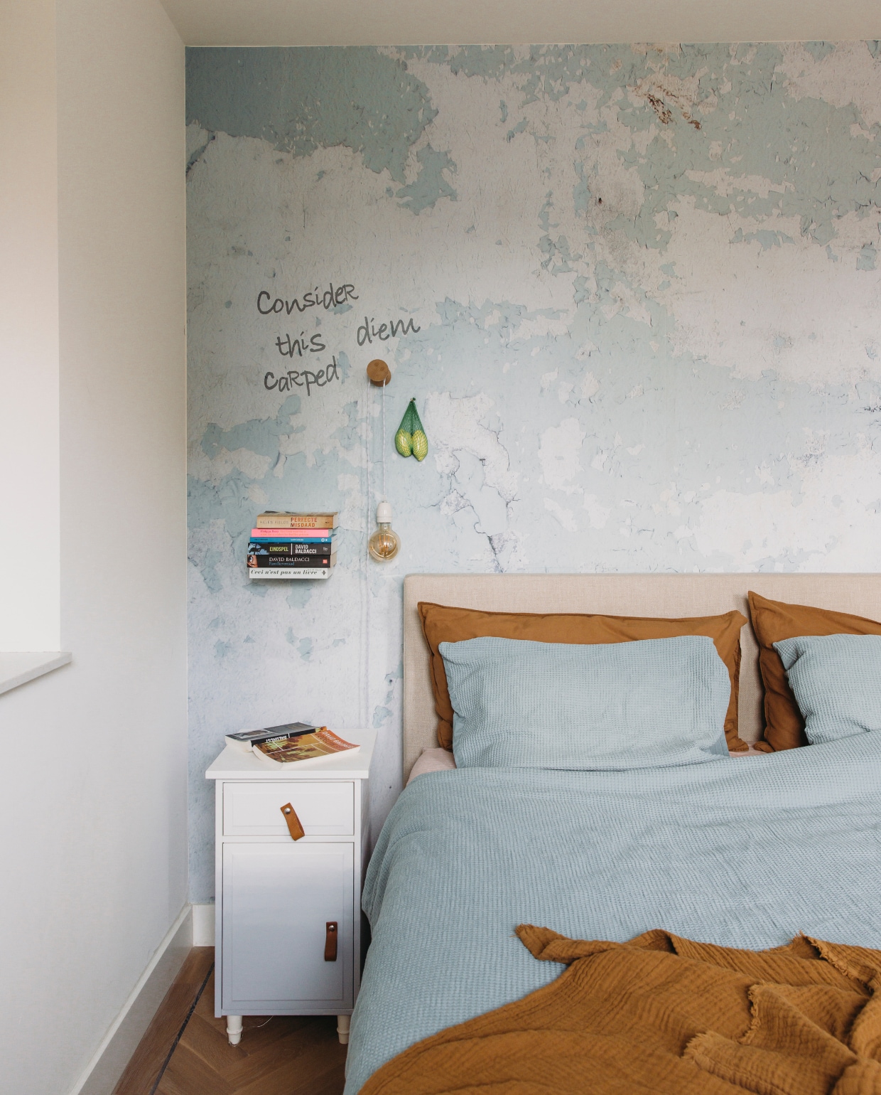 Bed Scapa Home. Geverfde nachtkast Ikea. Uitvergrote foto als behang repro.nl. Boekenplank Selfshelf. Dekbedovertrek Hema. Lamp DIY. vtwonen DIY-special 11-2024 | styling en productie Agnes Verduin | fotografie Eva Bloem