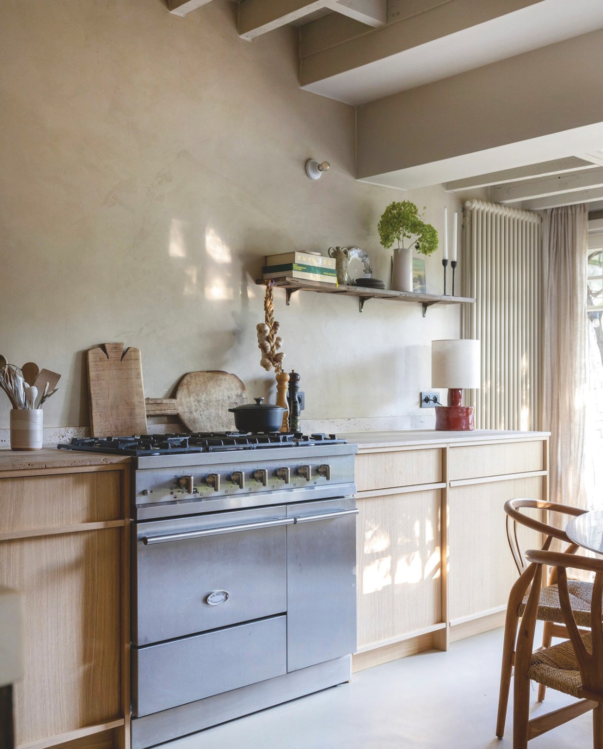 De keuken ontwierp Fammeke zelf. Hij werd op maat gemaakt door een meubelmaker. Fornuis van Lacanche. Plank boven de keuken gemaakt van een tafelblad van een bureau dat Fammeke over had. vtwonen landelijk 01-2025 | fotografie Sarah van Hove