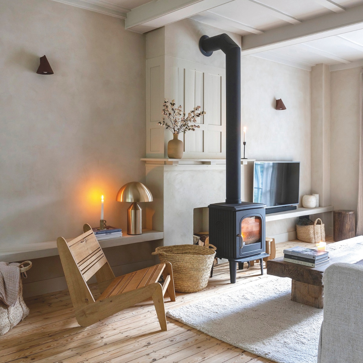 Fammeke en Neil lieten het plafond openbreken, waardoor de oude houten balken zichtbaar werden. De houten stoel maakte Neil zelf. vtwonen landelijk 01-2025 | Fotografie Sarah van Hove