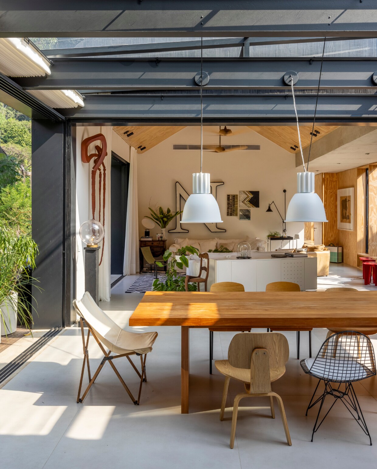 Stoelen door de jaren heen verzameld door Breno. Hanglampen Lumini. Tafel van Zuid-Amerikaans tauarihout. vtwonen 01-2025 | styling Simone Raitzik | fotografie Andre Nazareth