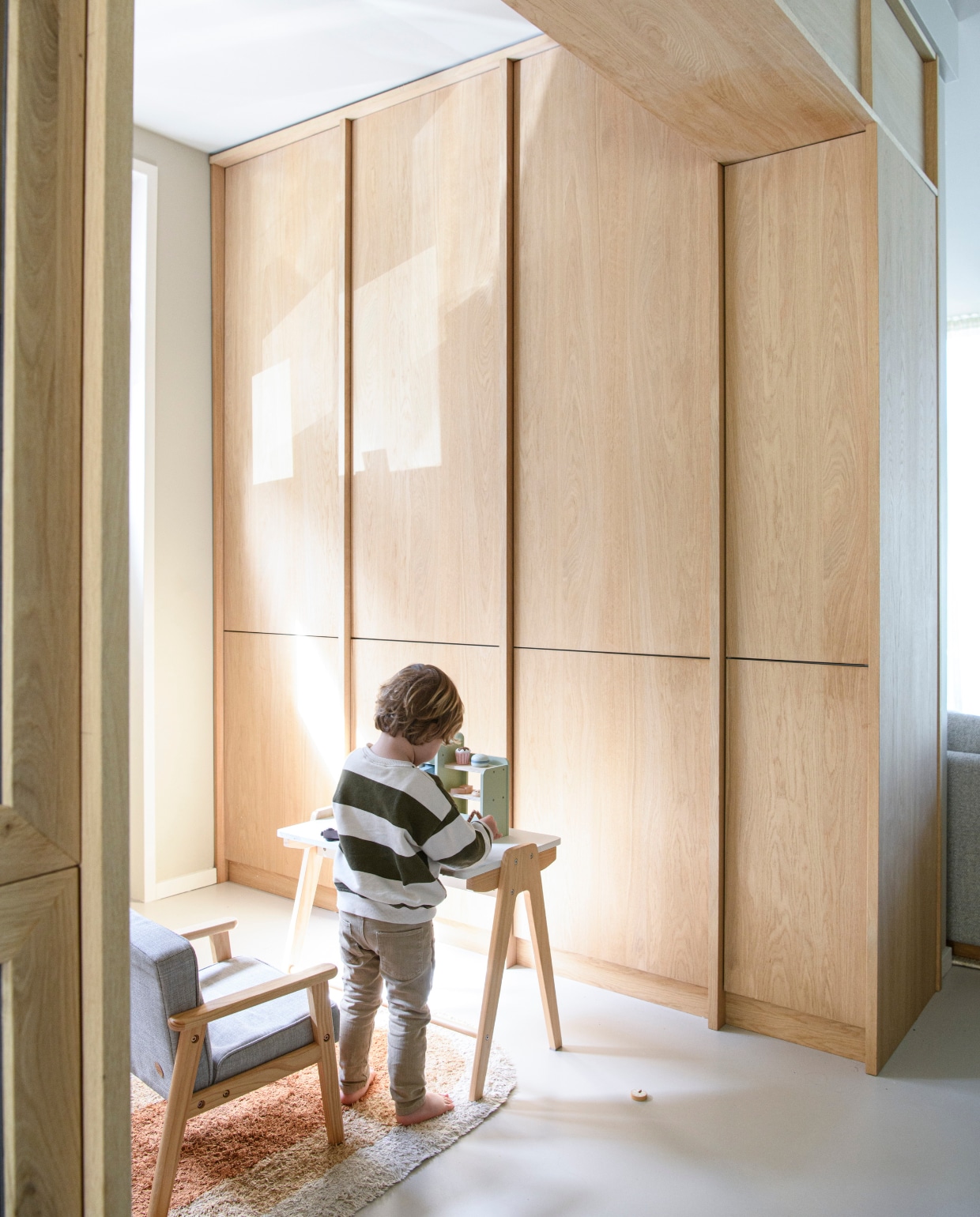 Zoon Jip in de halfopen speelhoek. Tafel en stoel Petite Amélie. Vloerkleed KidsDepot. vtwonen 01-2025 | styling Esther Loonstijn | fotografie Louis Lemaire